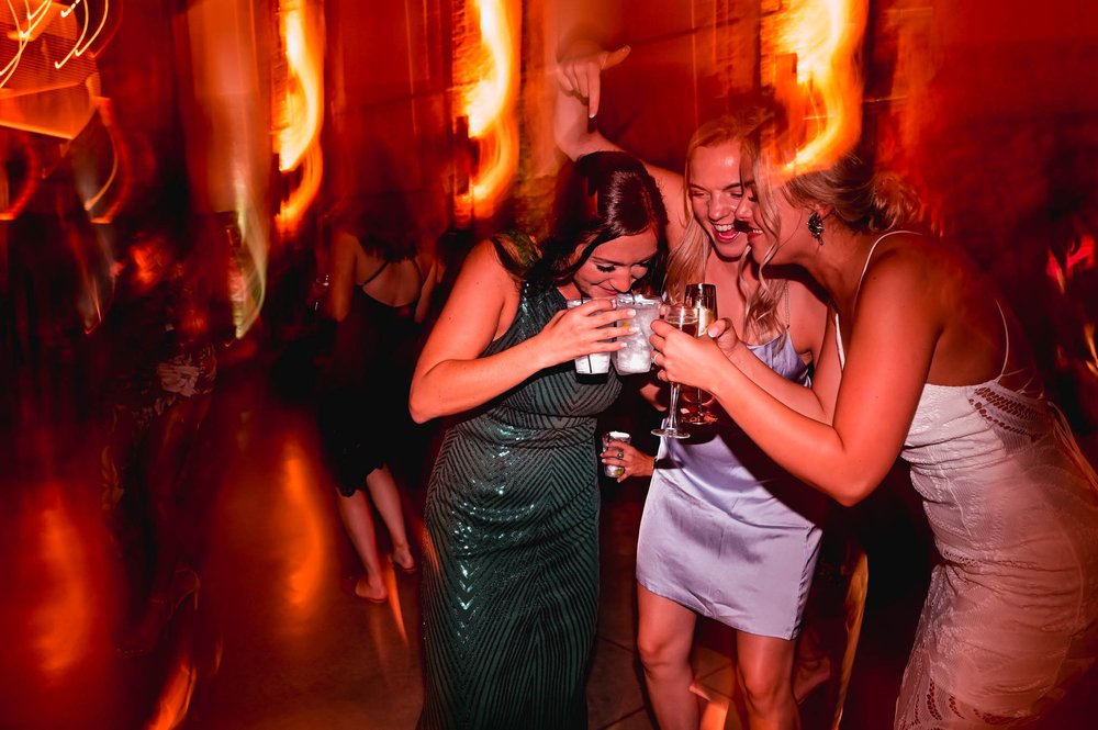 bridesmaids sips down two drinks during the wedding reception