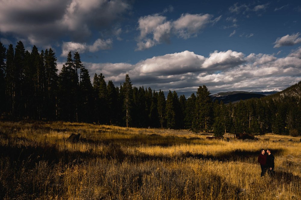 couple stand in a field in the sunlight outside of breckenridge