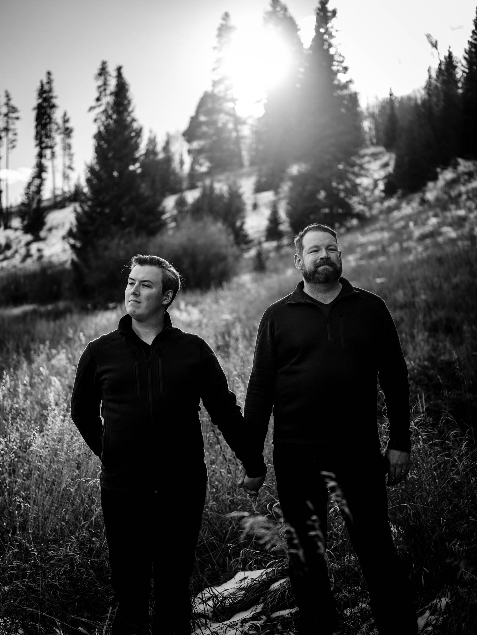 couple stand and hold hands during sunset in breckenridge