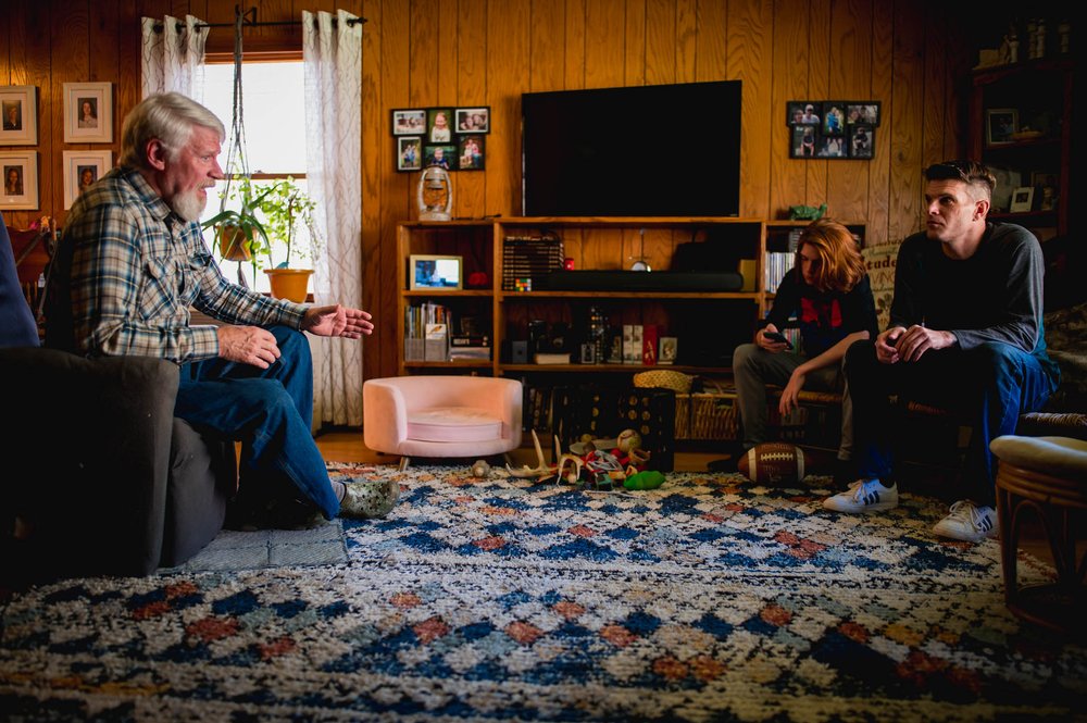 grandfather talking to son in law and grandson in the living room