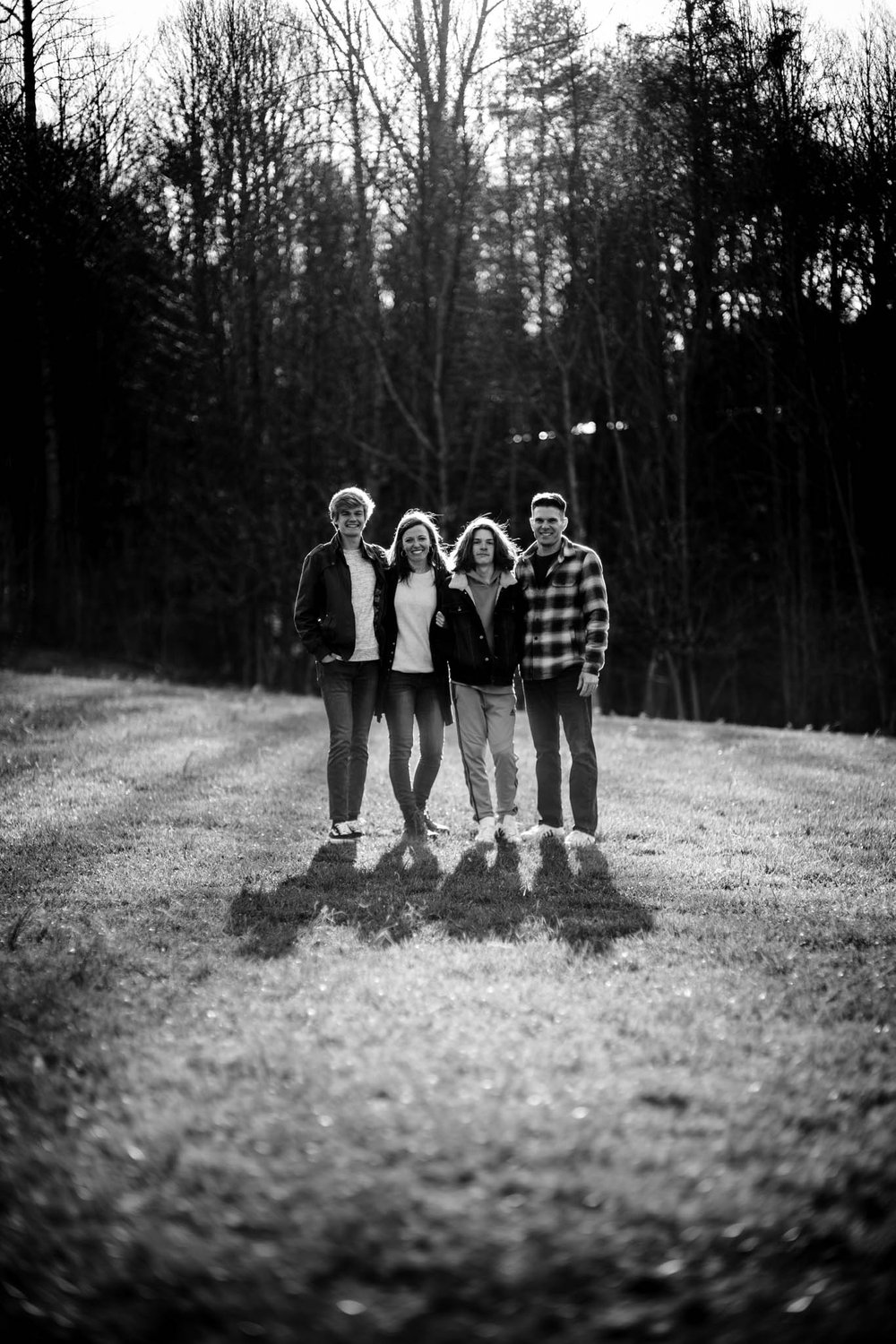 family poses for a photo in an open field