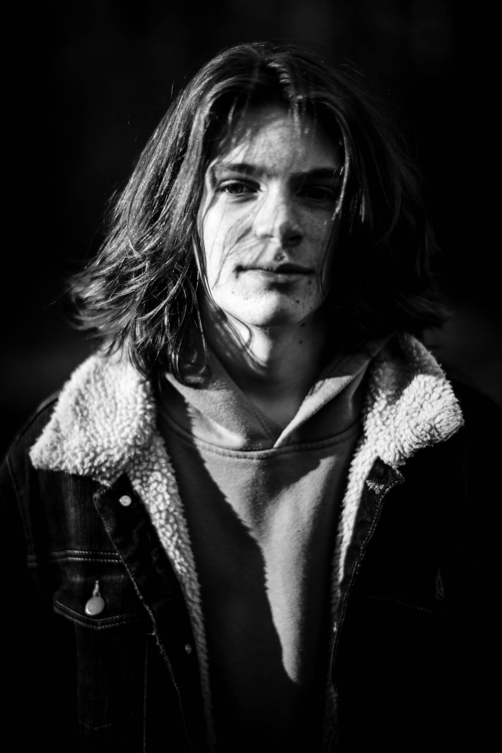 dramatic portrait of boy with long hair staring into the camera