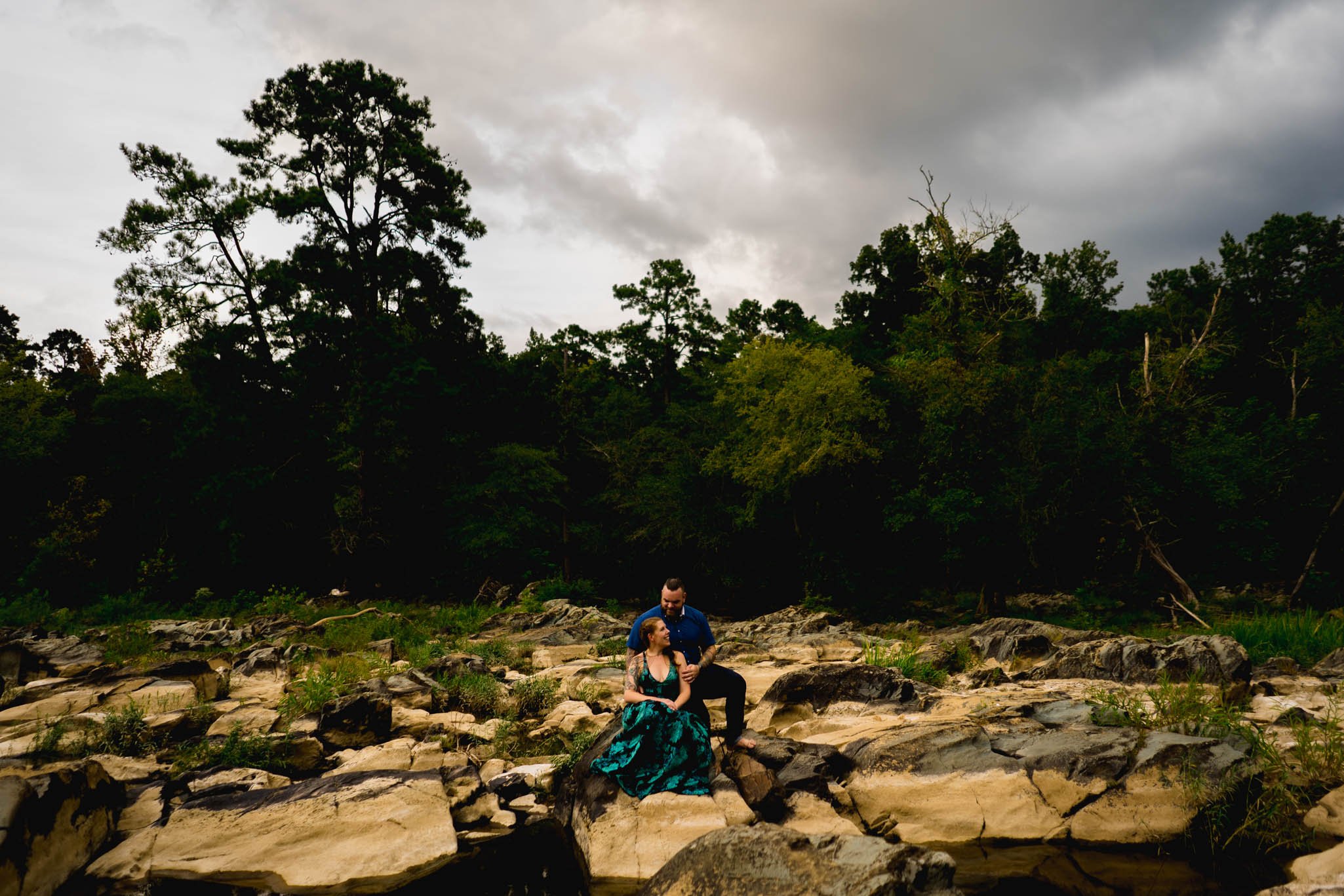 couple sit out amongst the rocks in a river