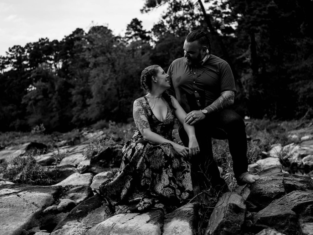 couple pose together on boulders in a river