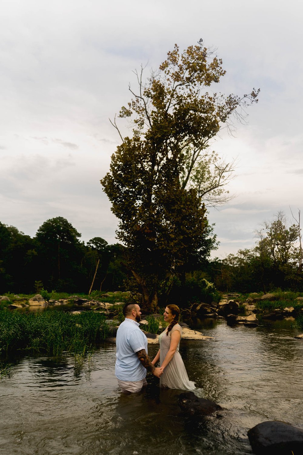 couple sharing their vow renewal while standing in a river pool