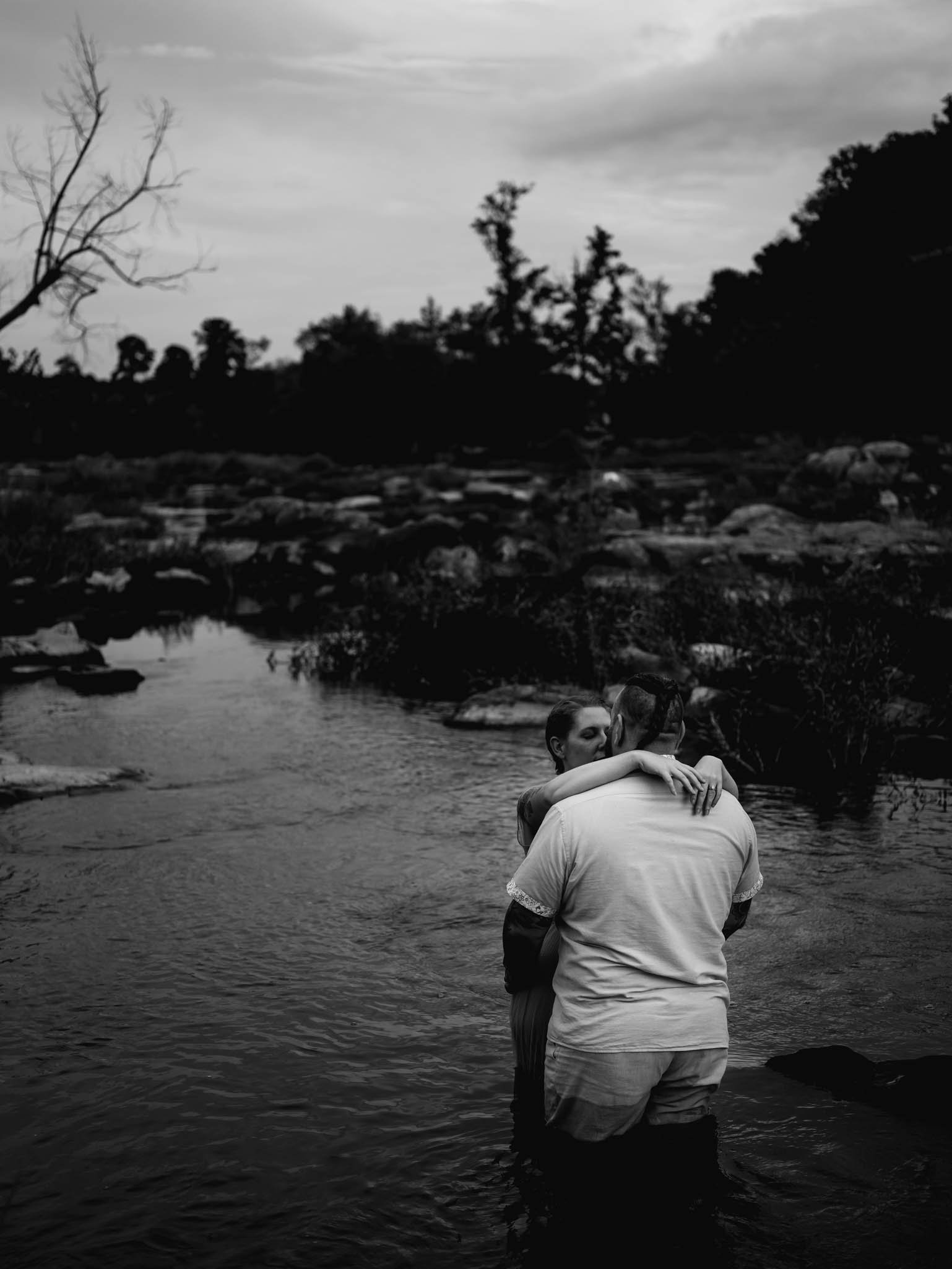 couple kiss while standing in a river