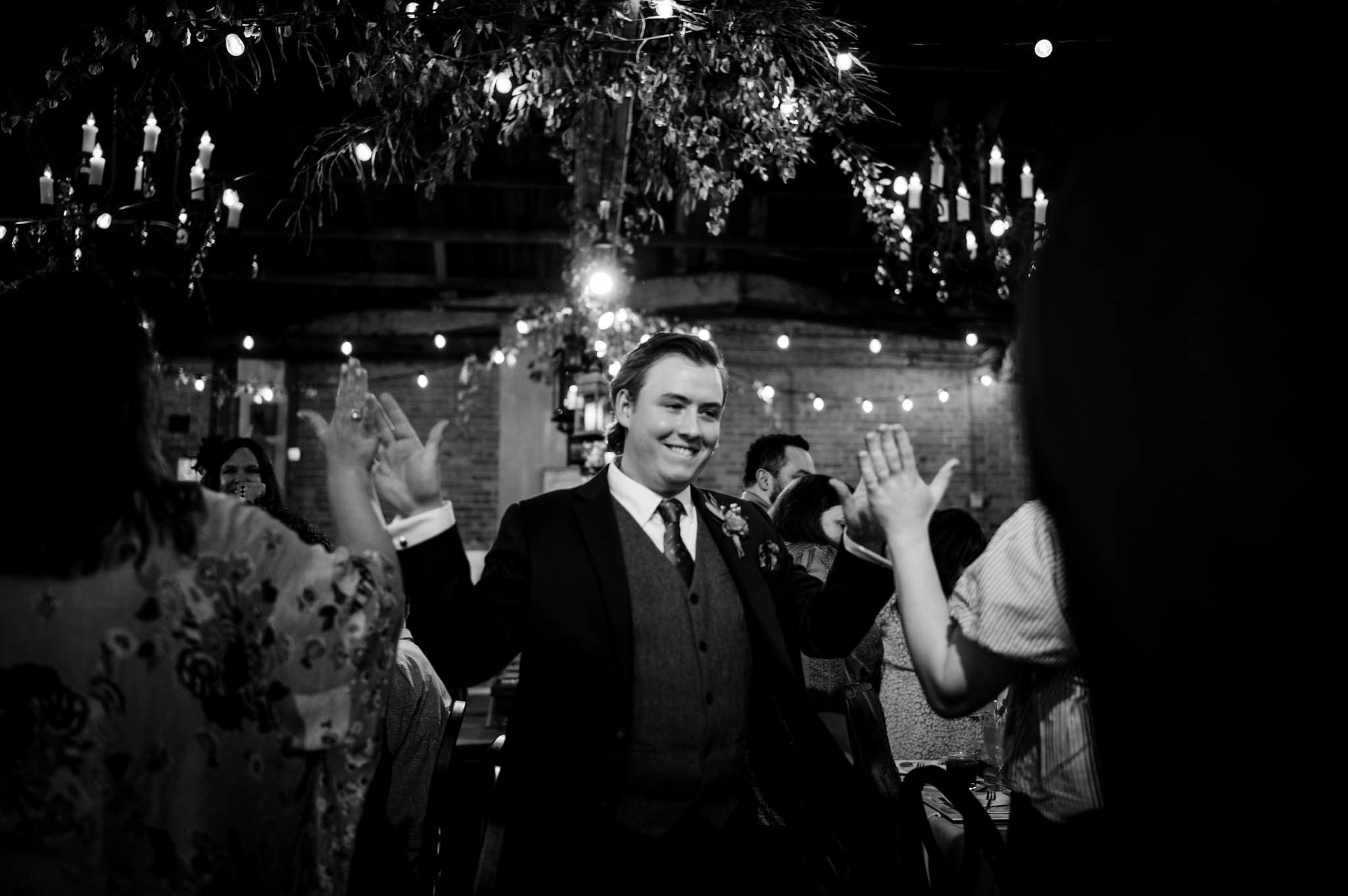 a groom joins the reception giving high fives to everyone