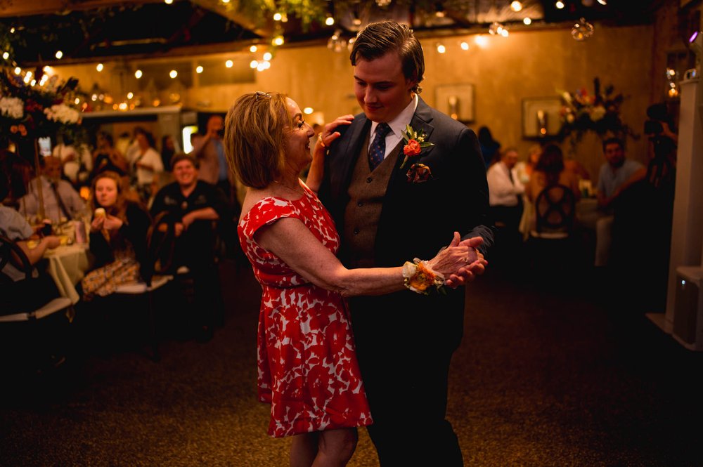 a groom dances with his mother at his wedding