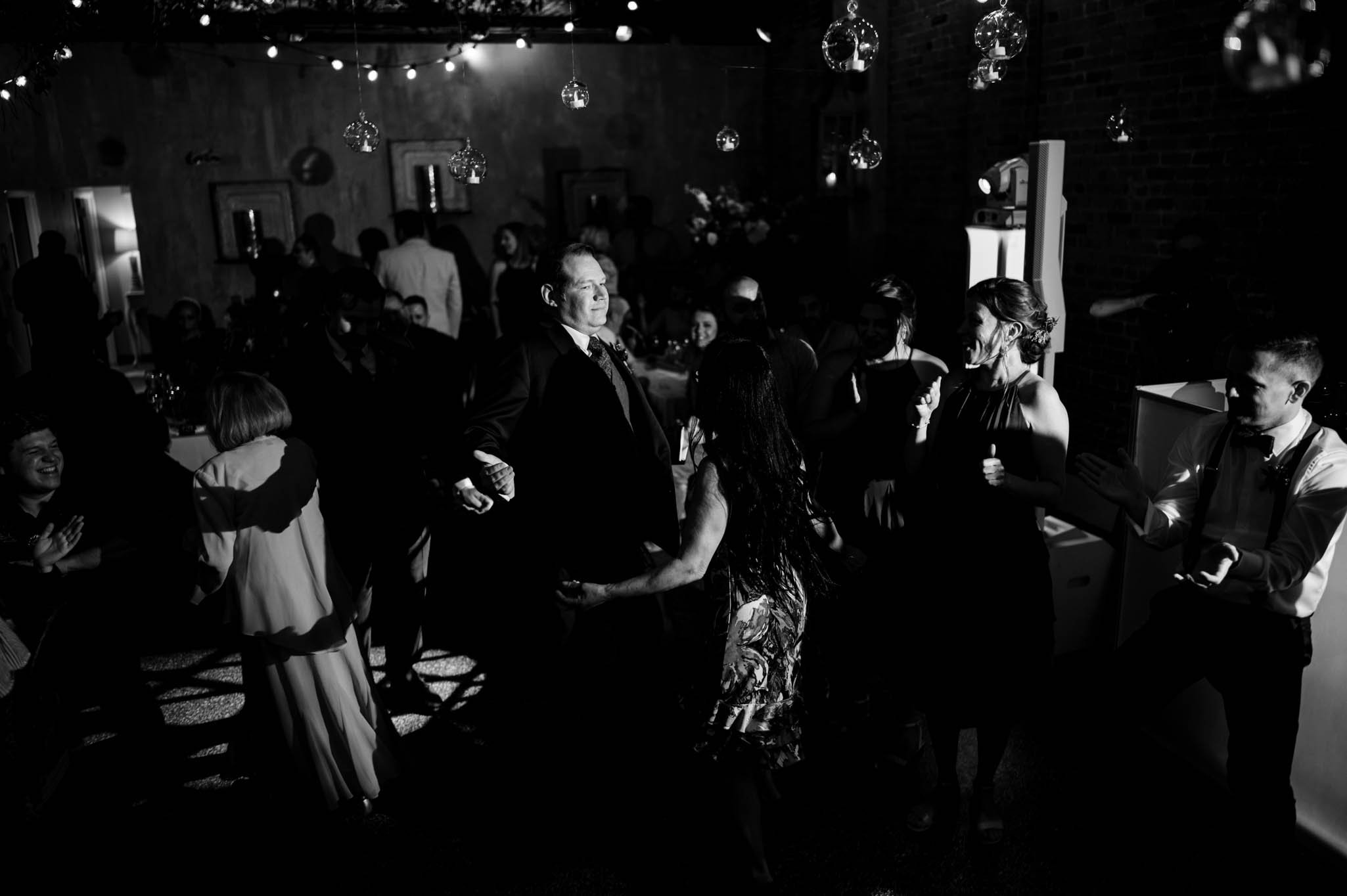 a groom dances with family and friends during the wedding reception