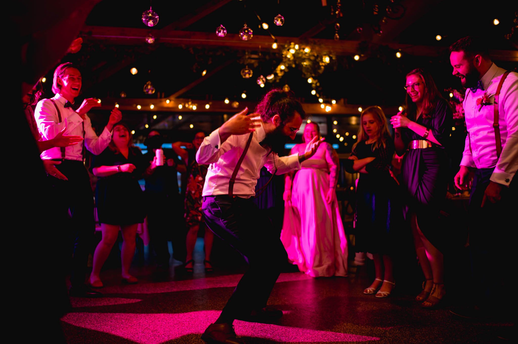 a wedding party guest dances hard during the wedding reception