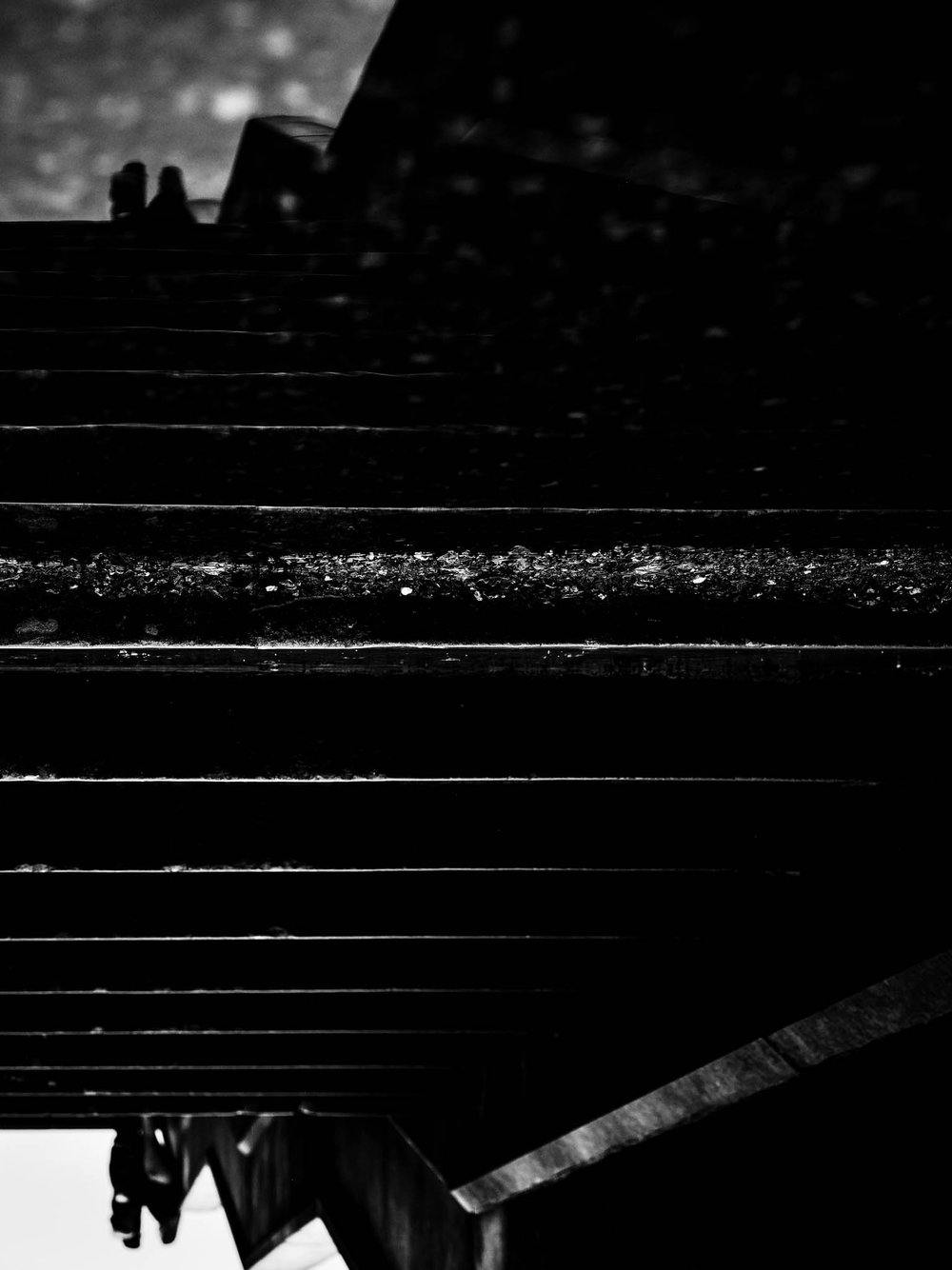 reflection of the couple in a puddle at the base of the stairs