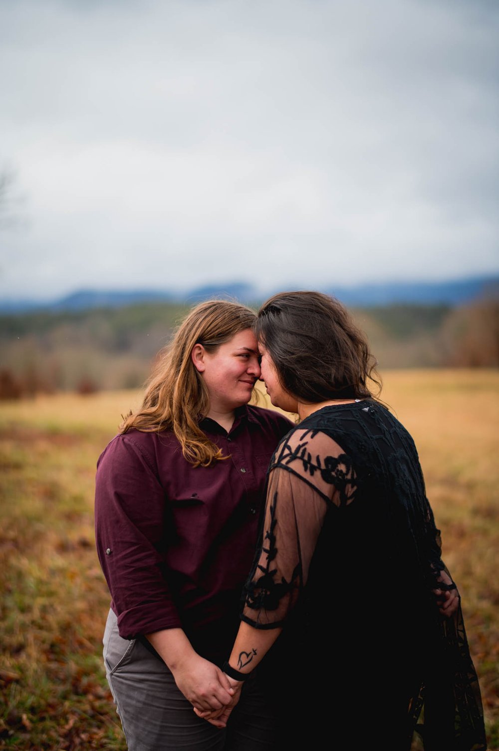 couple embracing with the Pisgah national forest behind them