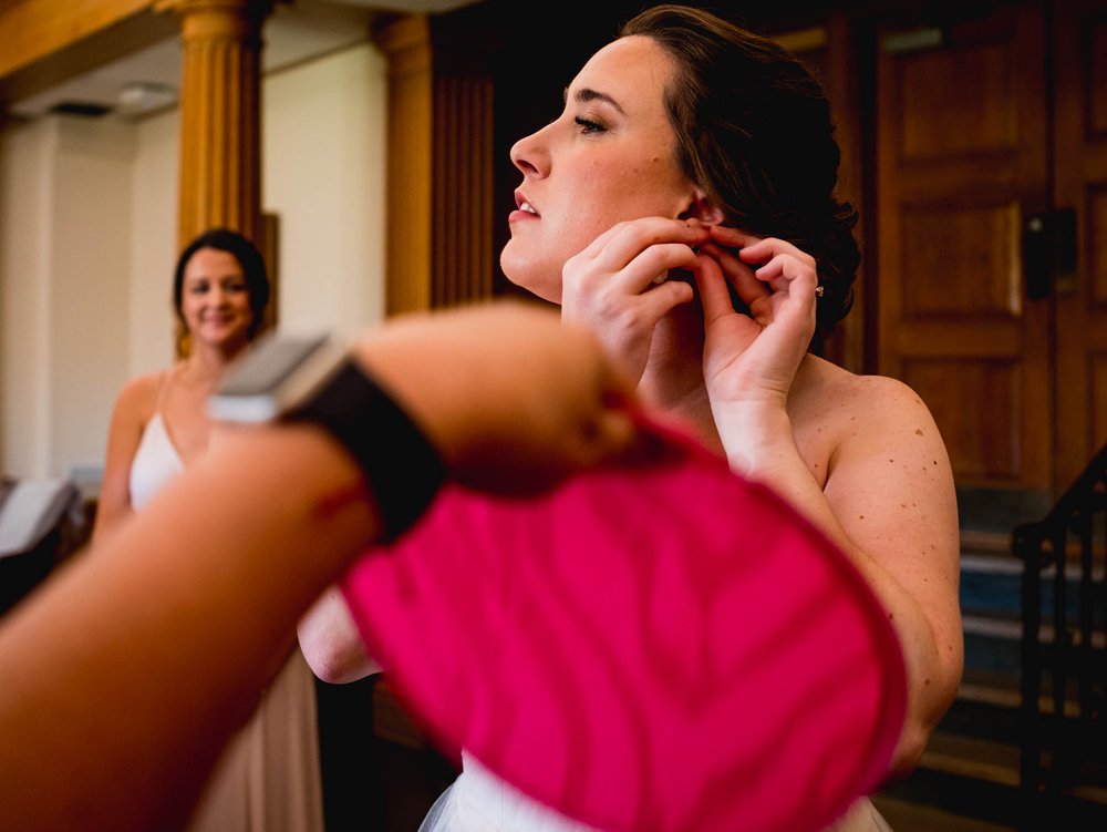 bride being fanned while putting in her earings