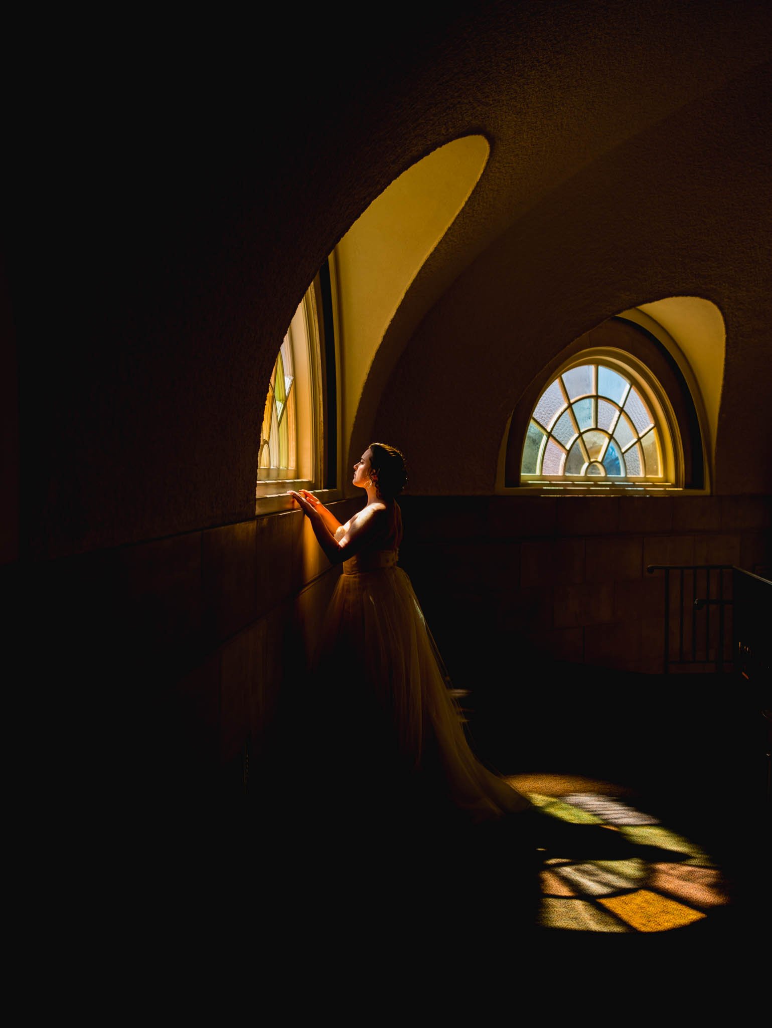 bride looking through the stained glass of Wait Chapel