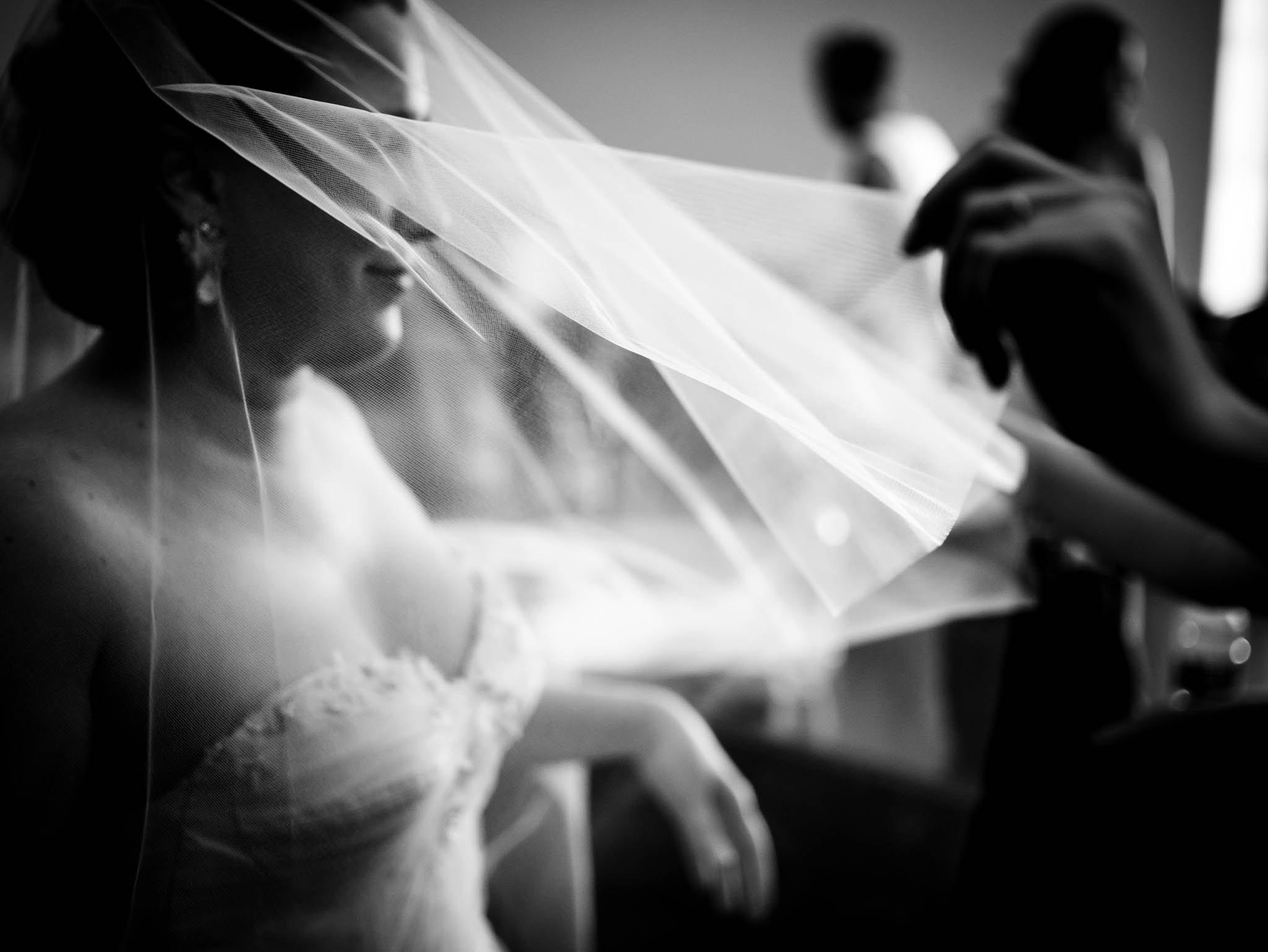 bride is helped with her veil before the ceremony