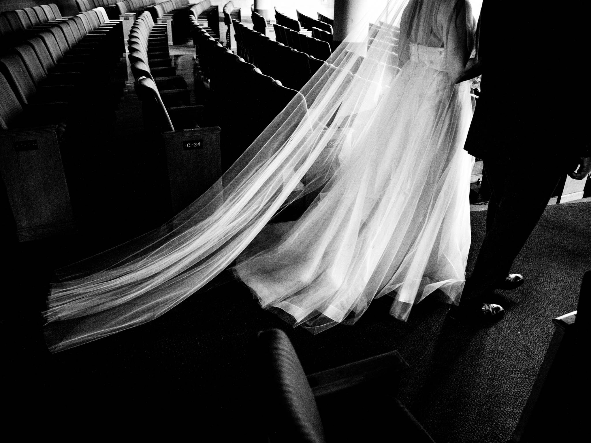 brides train and veil as she and her father walk down the aisle of Wait Chapel