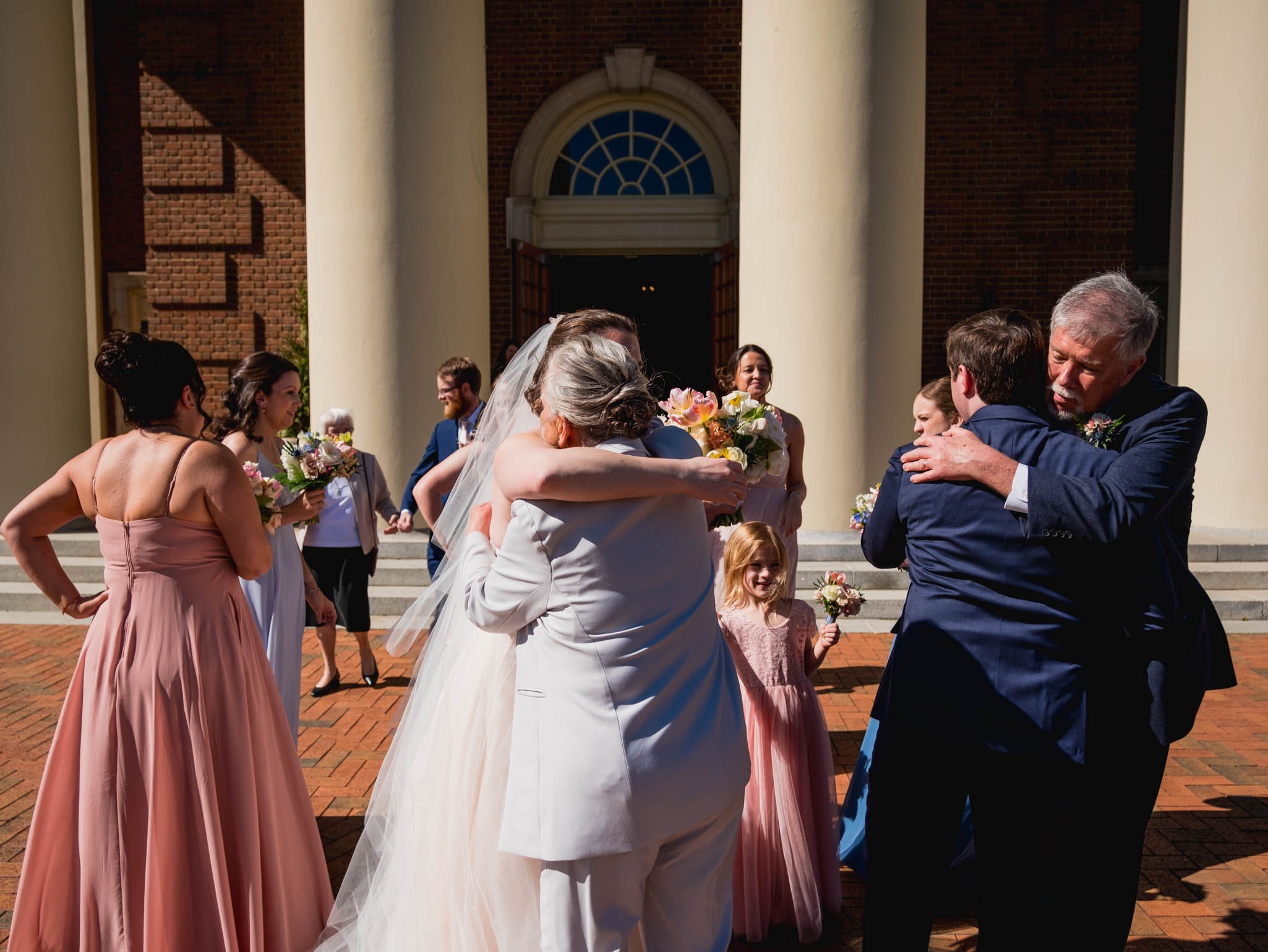 bride and groom hugging their parents after their wedding ceremony