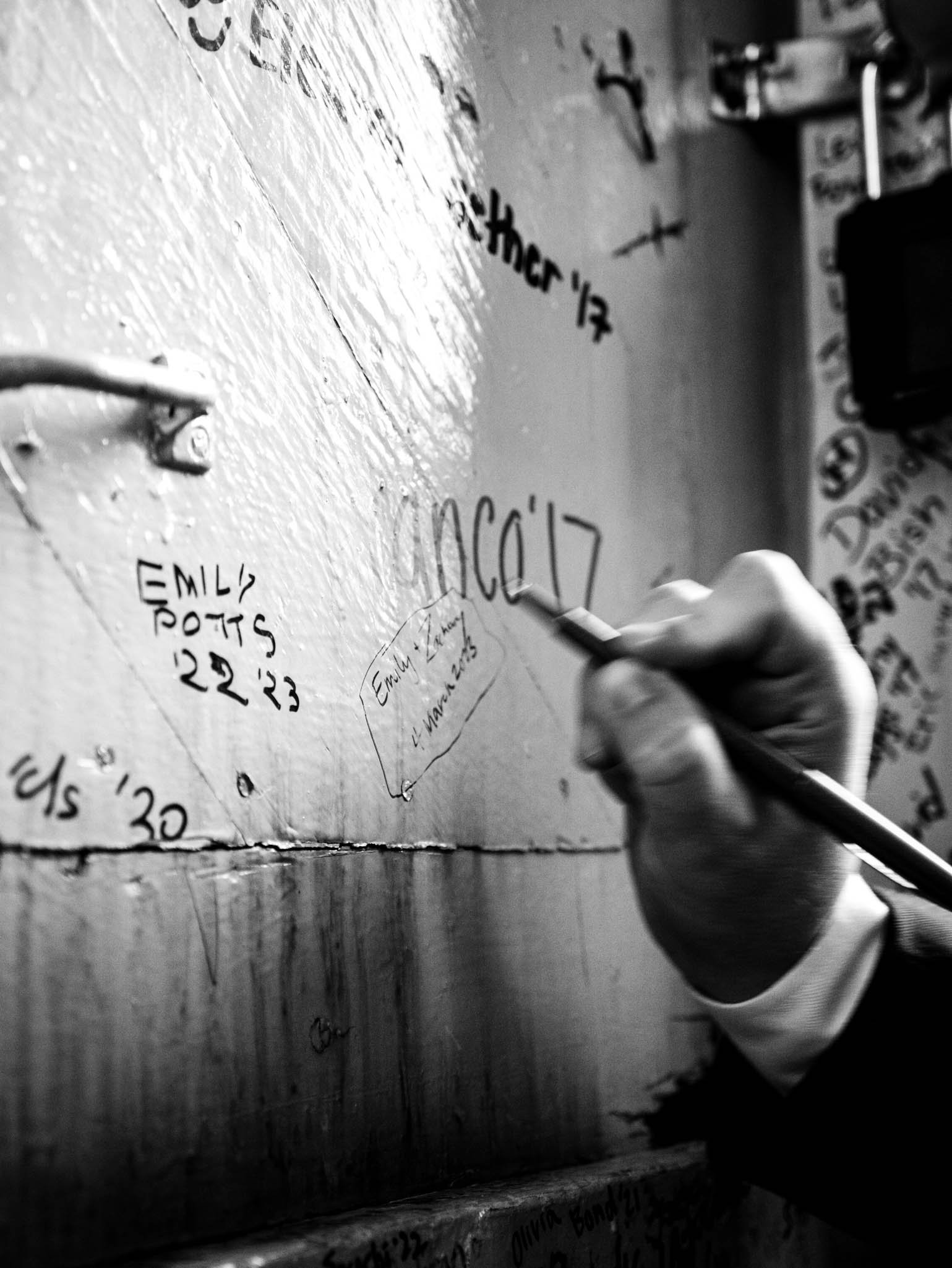 groom signs the famous walls of the inside of the Wait Chapel bell tower