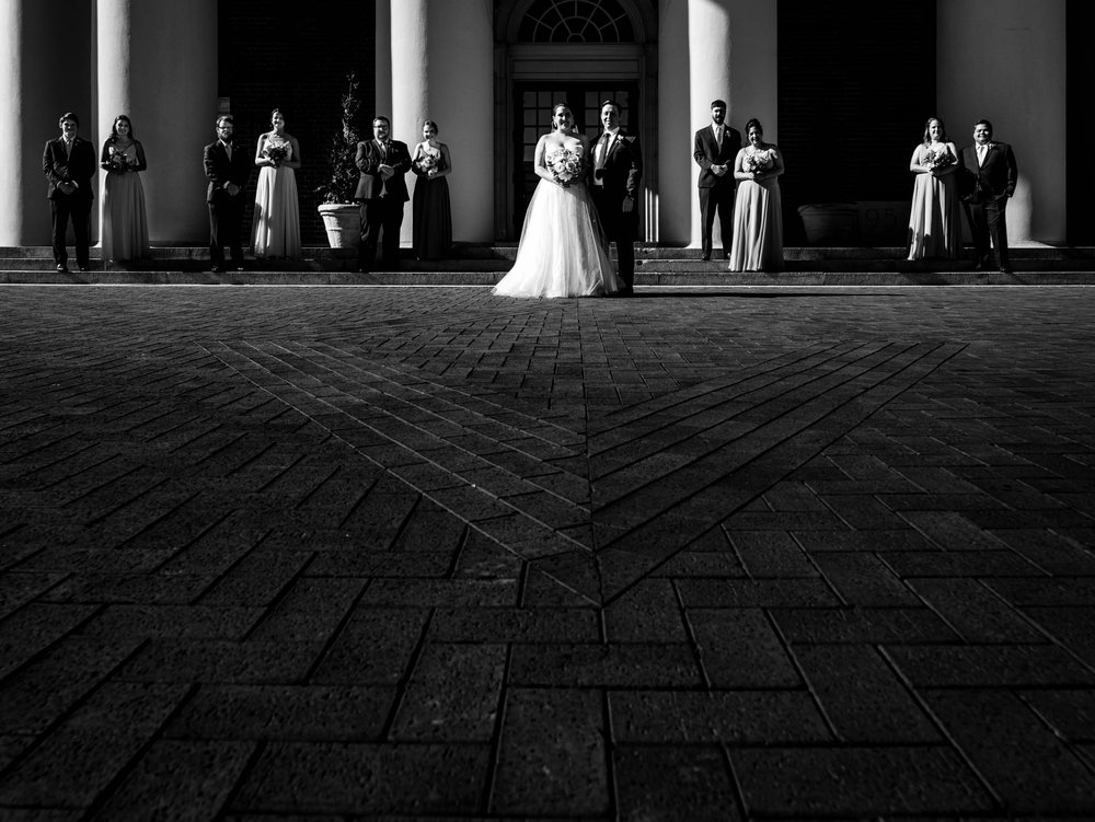 the wedding party standing in the light and shadow outside of Wait Chapel