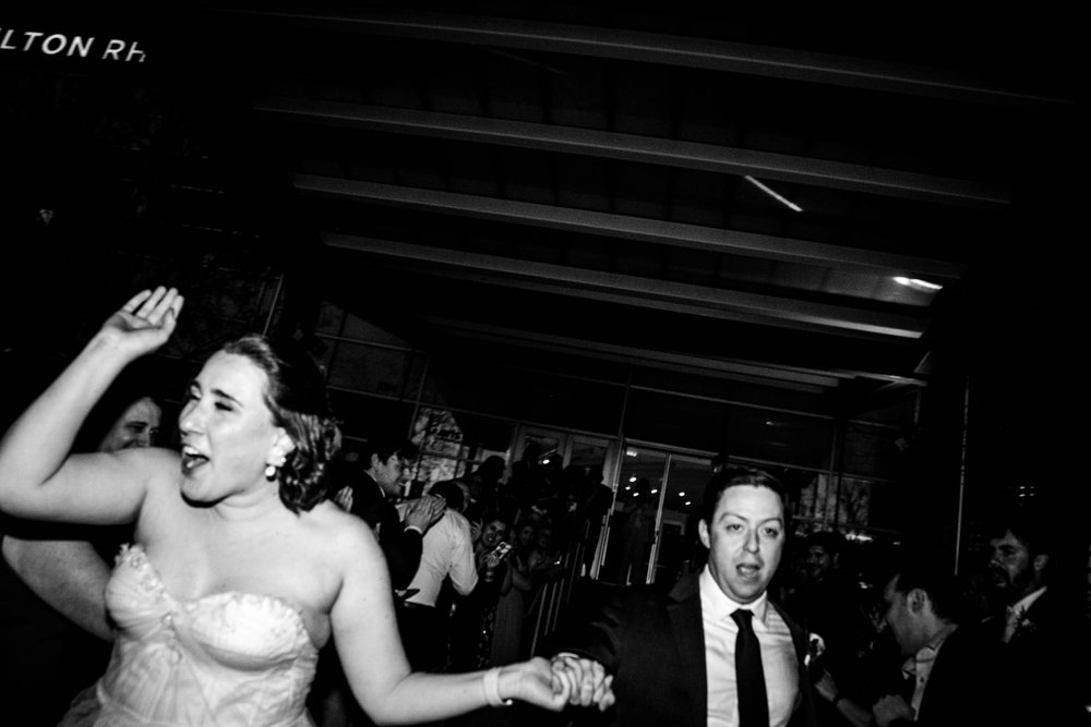 bride and groom running through their exit after their wedding reception at Milton Rhodes Center for the Arts