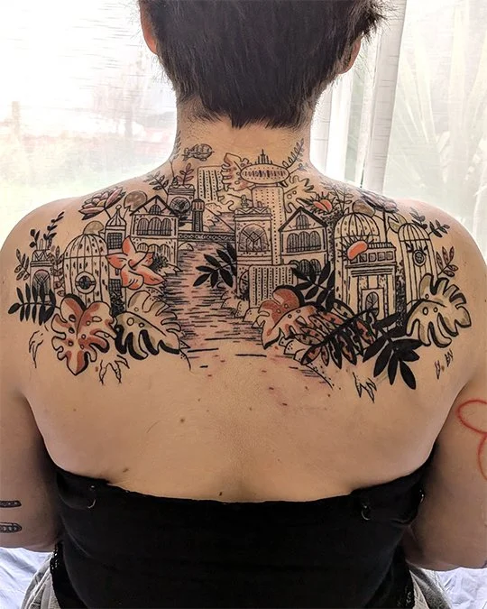 Tatouage d'un dos en couleur représentant une ville recouverte par la végétation, réalisé par Camille Tardif