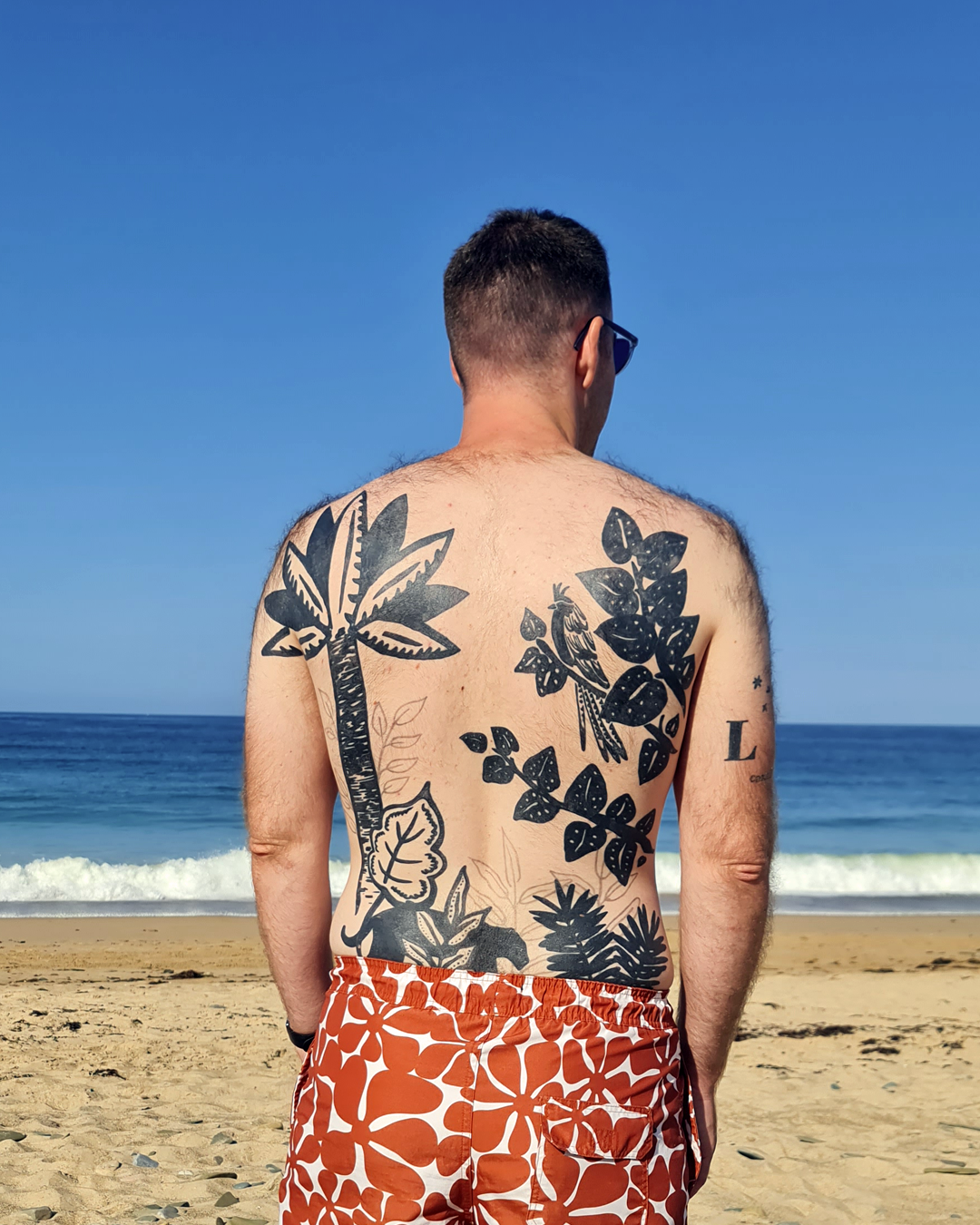 Un tatouage de dos complet représentant un décor végétal réalisé par Camille Tardif