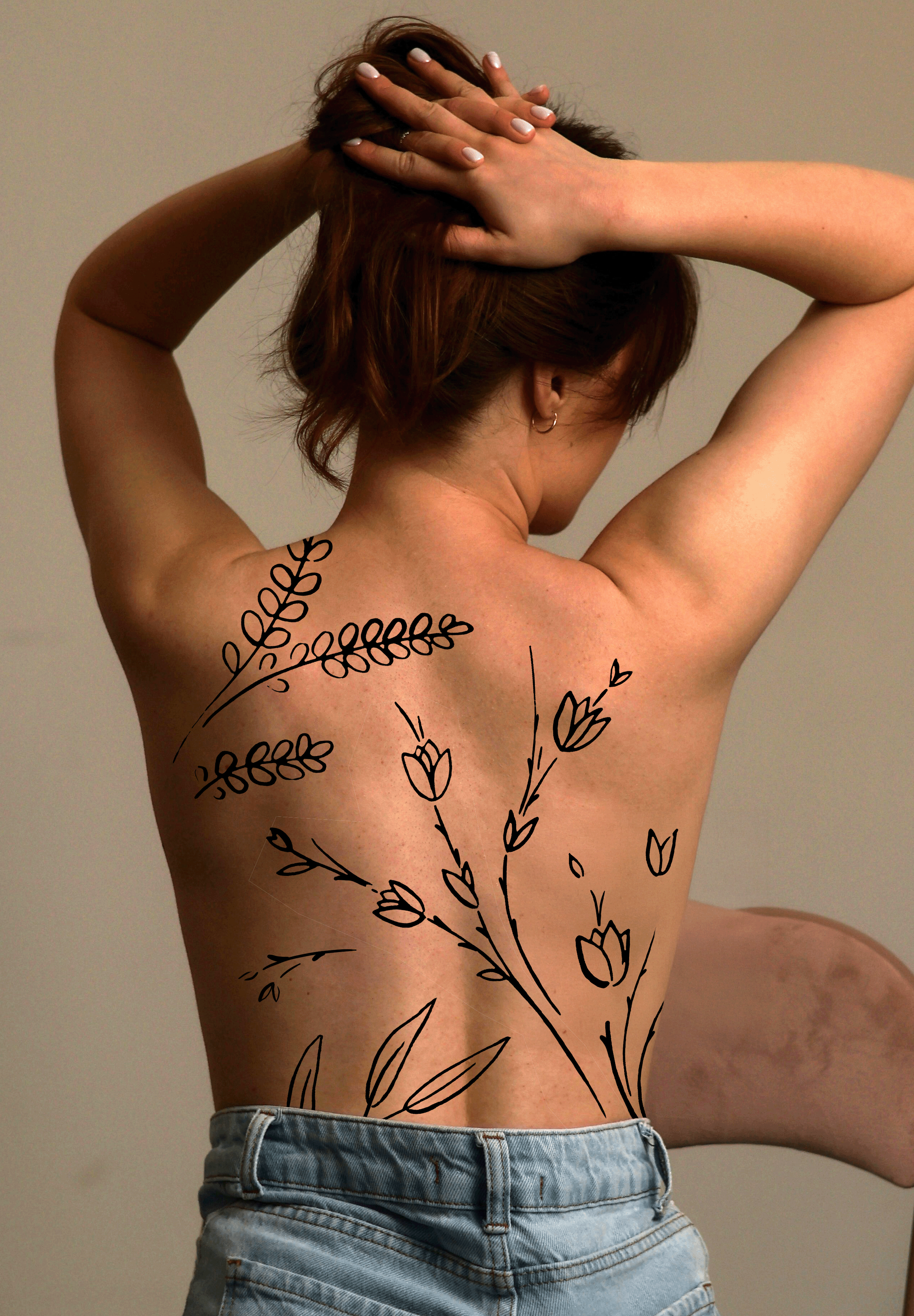 Une femme nue de dos, tenant sa tête avec ses mains, avec des dessins de fleurs noires esquissées sur son dos.