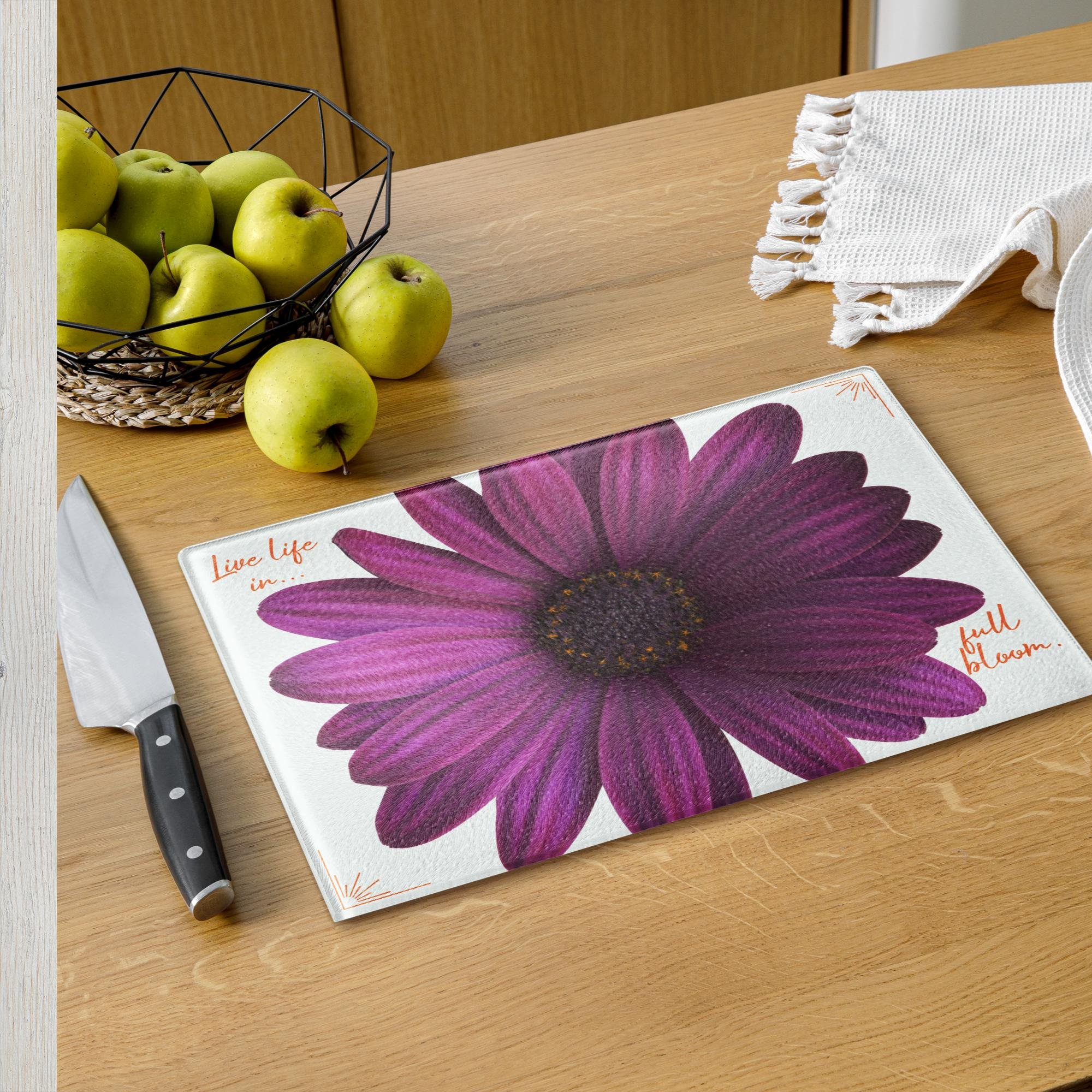 A tempered glass serving board with purple daisy.