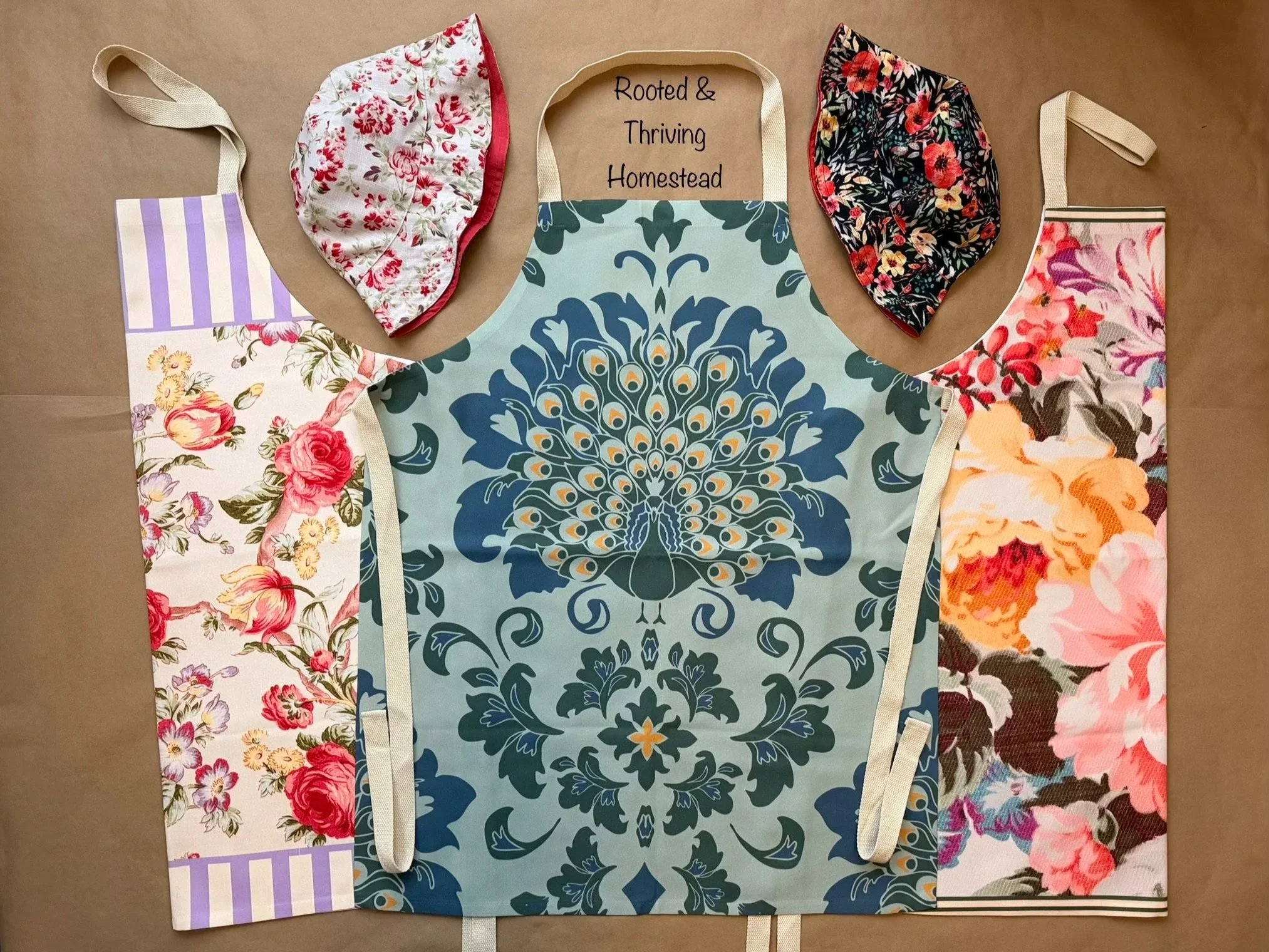 Aprons and bucket hats featuring floral and peacock designs created by Rooted and Thriving Homestead