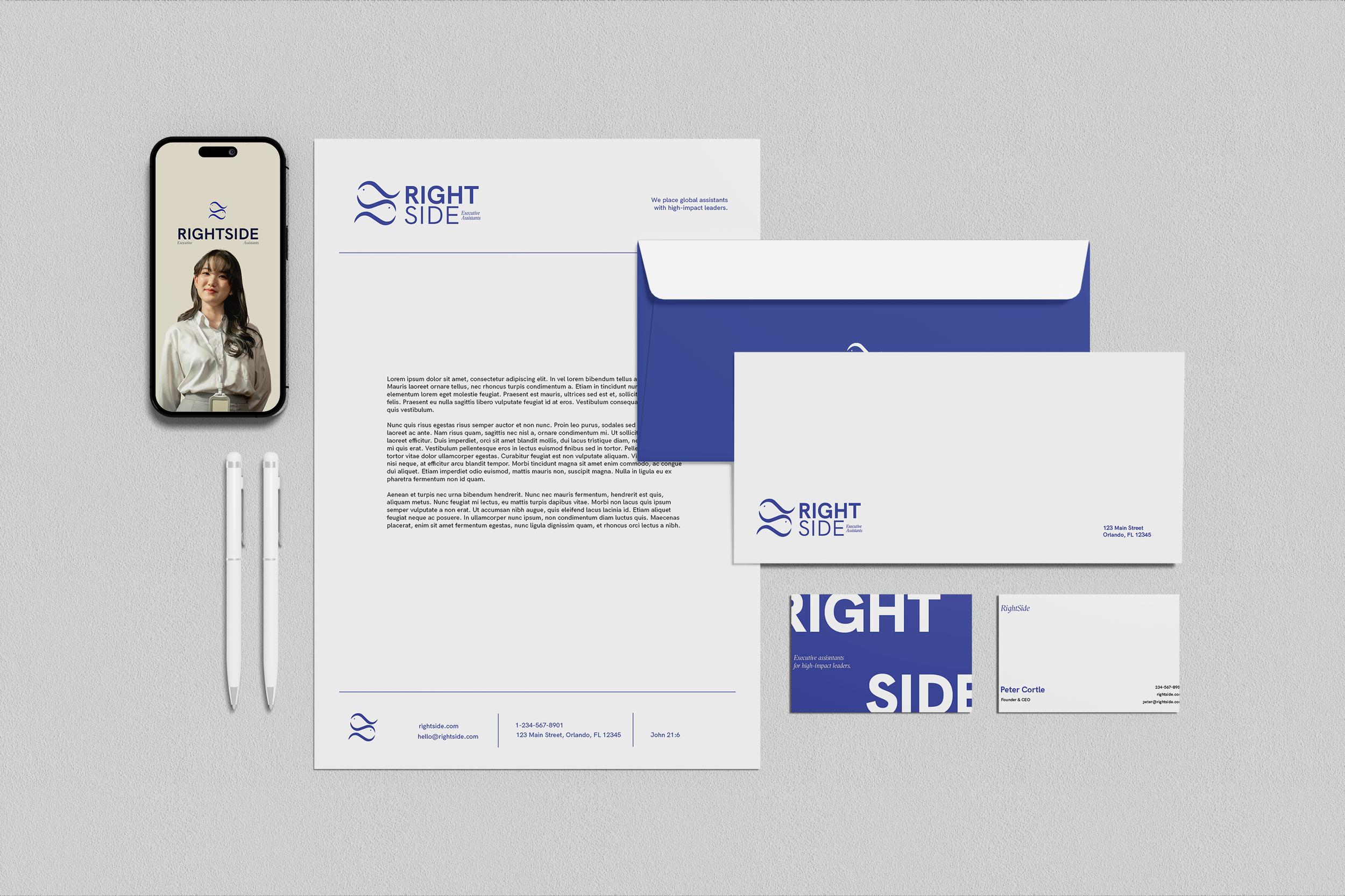 Business branding materials for 'Right Side' including a smartphone displaying a woman, letterhead, envelopes, business cards, and pens on a grey surface.