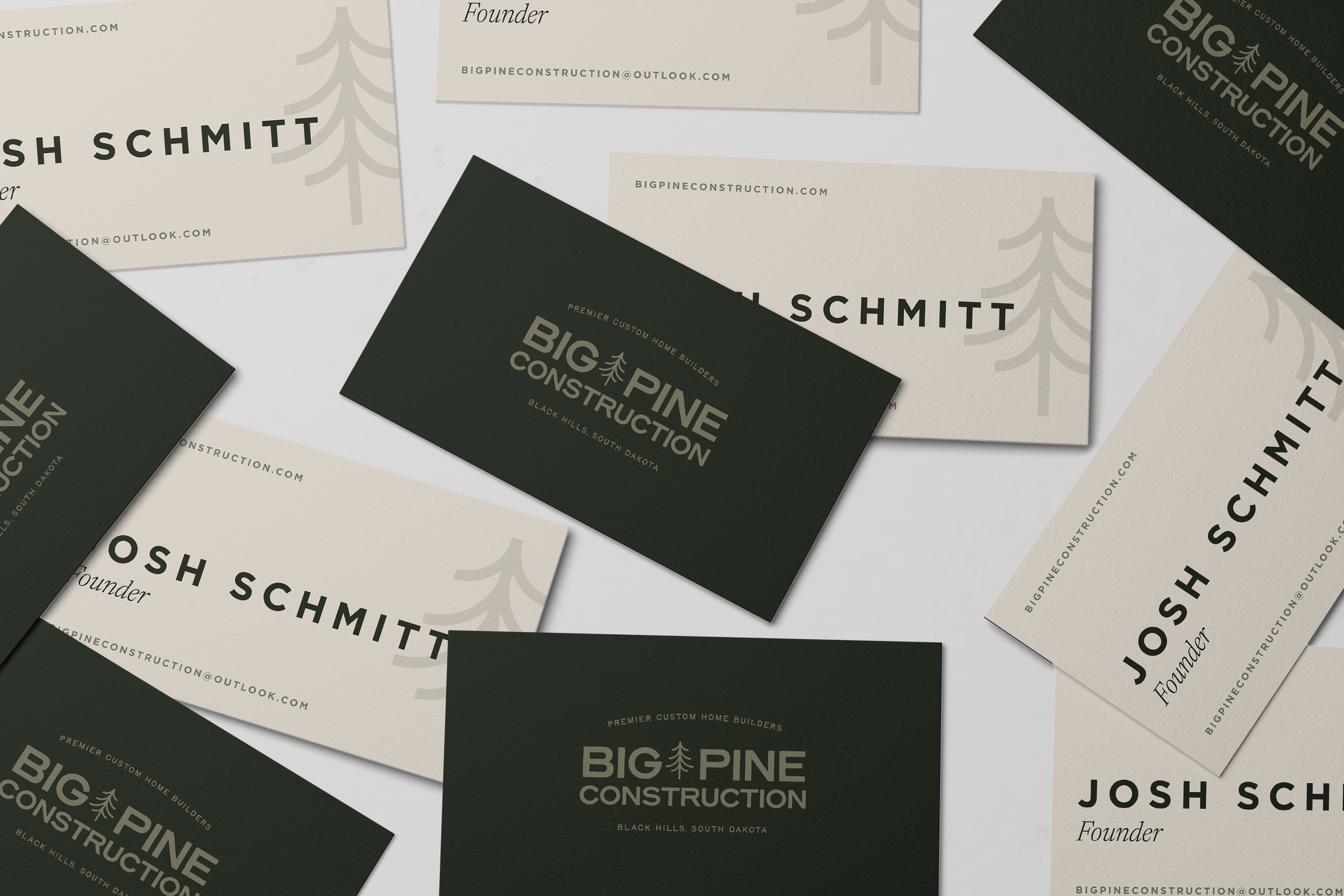 Multiple business cards for Big Pine Construction, a home builder company in Black Hills, South Dakota. The cards are in black and beige with a pine tree logo and contact information.
