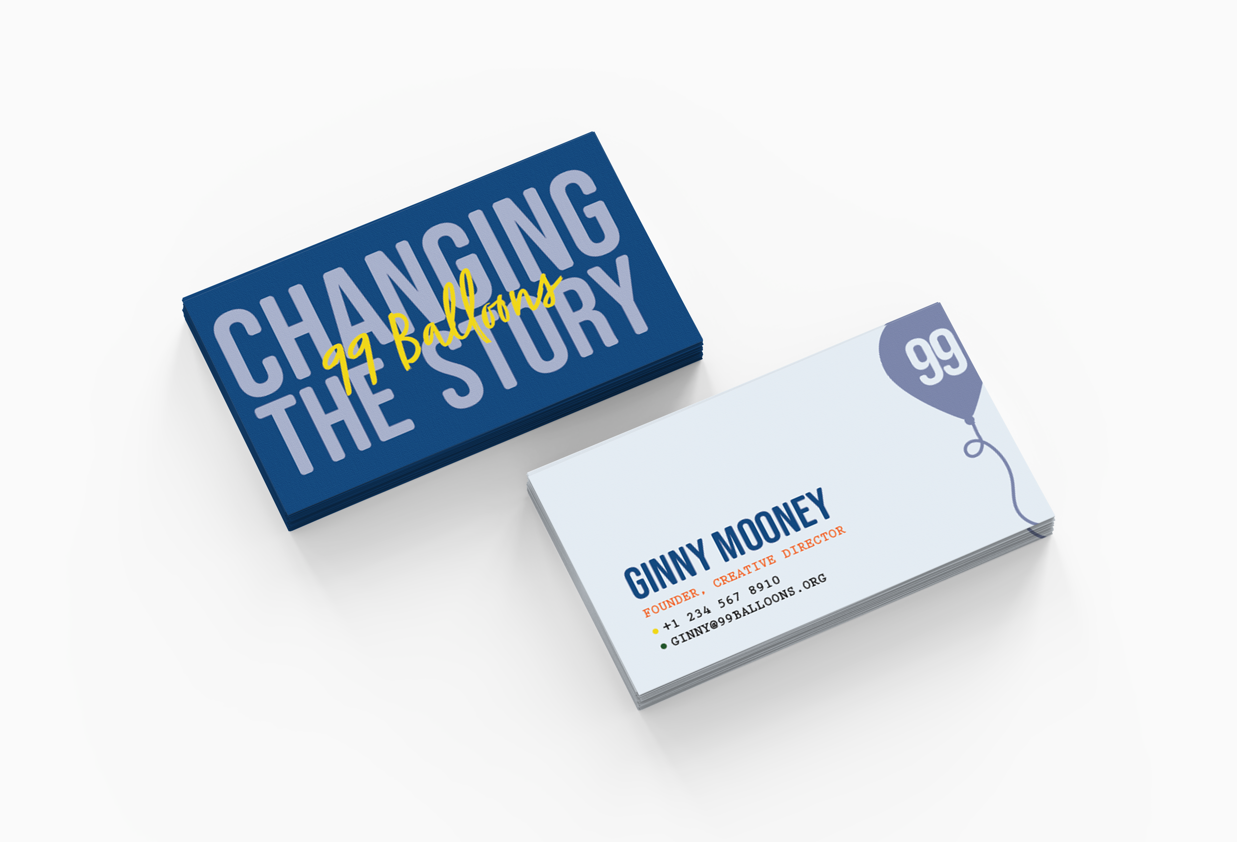 Stacked business cards with one card reading 'Charming the Story' and the other 'Ginny Mooney, Founder, Creative Director'.