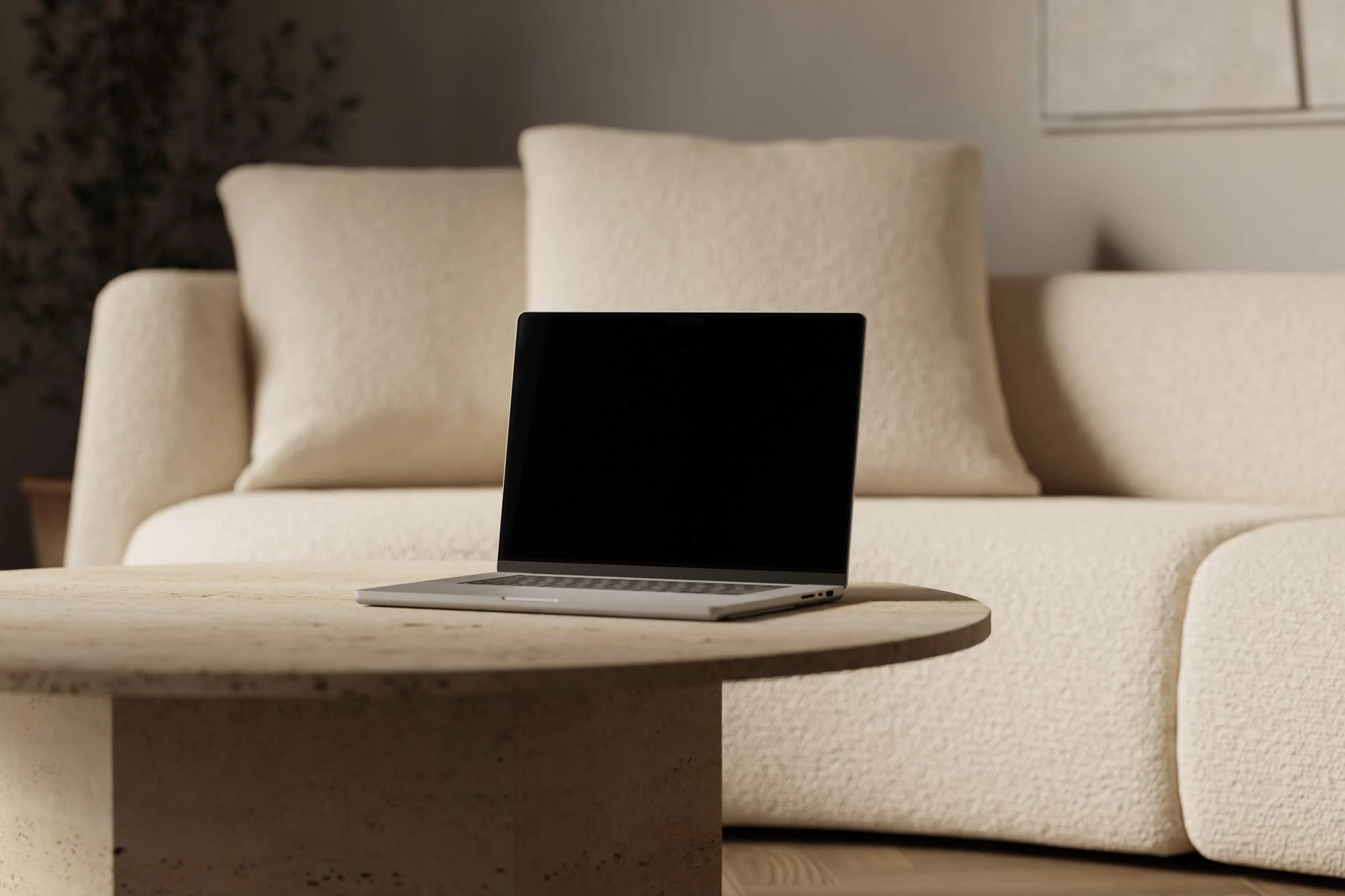 Macbook sat on a round table in front of a sofa. Text overlaid over the top of the laptop saying 'Featured, why your design shouldn't just be pretty. Your design beyond pretty, crafting timeless masterpieces that speak to your audience, Read more