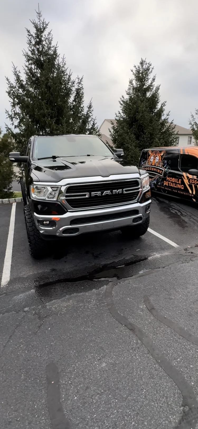 Gray Ram pickup truck with the Tigershine van behind it