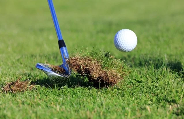 image of a golf iron taking turf divot