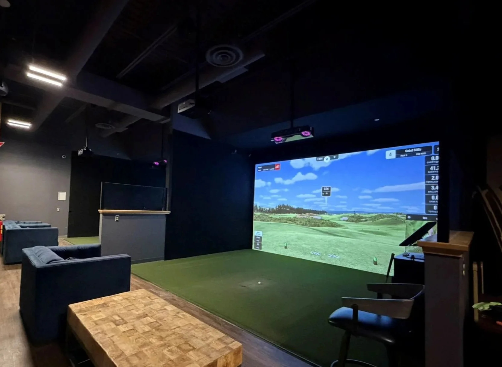 Room dimensions, lighting, screen size, and mounting location all influence projector selection. In this commercial simulator bay, a BenQ LK936ST 4K laser projector delivers a bright, immersive image with 5,100 lumens of output.
