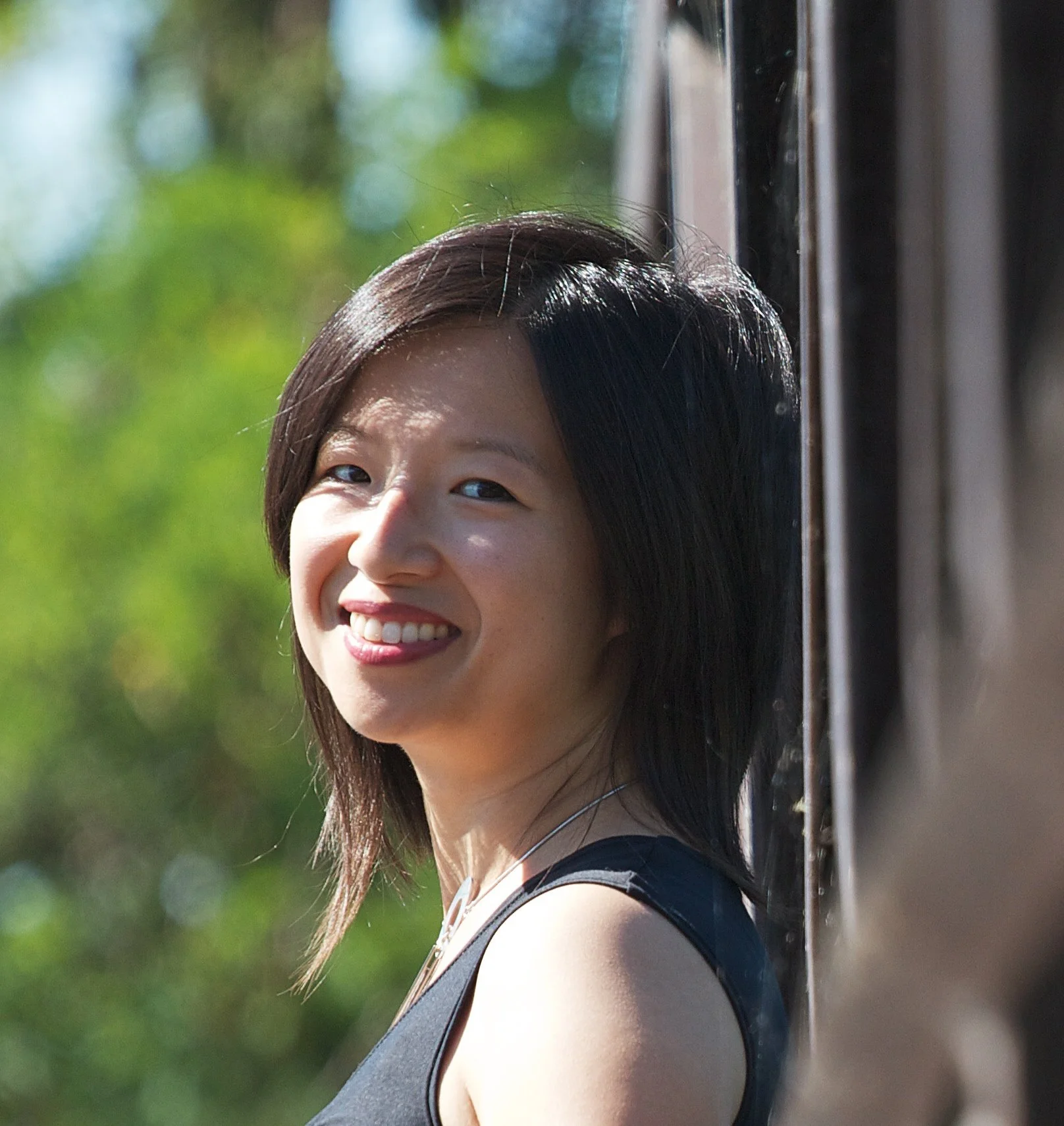 YS Lee is a woman with black shoulder-length hair, smiling in the sunshine