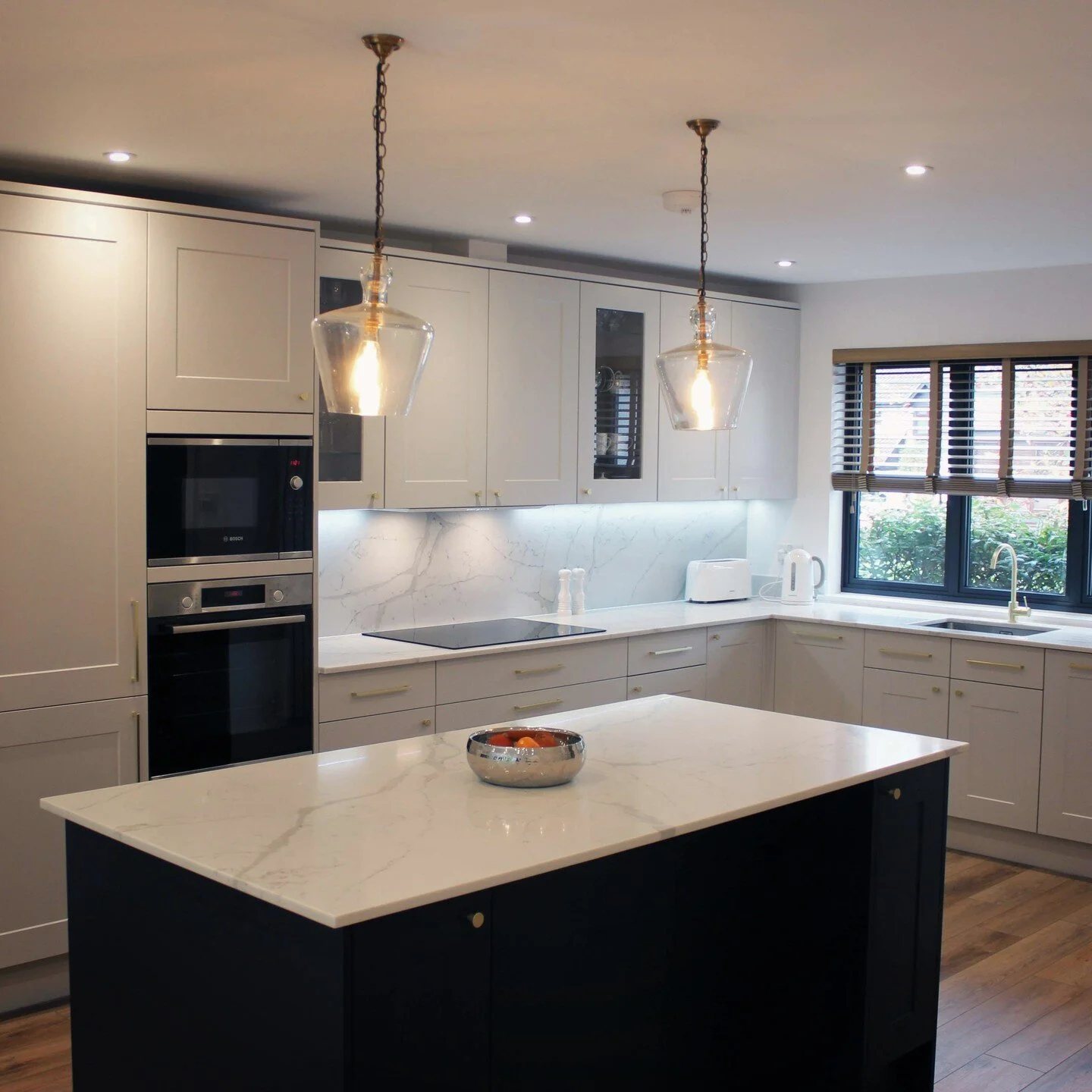 Shaker style island kitchen with grey and navy cabinets and brass ironmongery.

#shakerkitchen #kitchendesign #kitchenisland