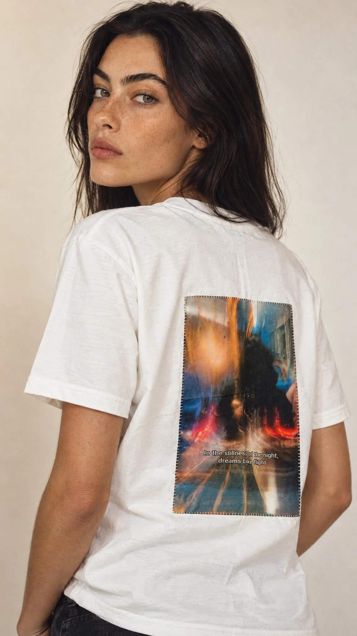 Female model wearing the Granite Island Biancu white T-shirt featuring a colourful fine art photograph printed on silk and hand-stitched onto the back.