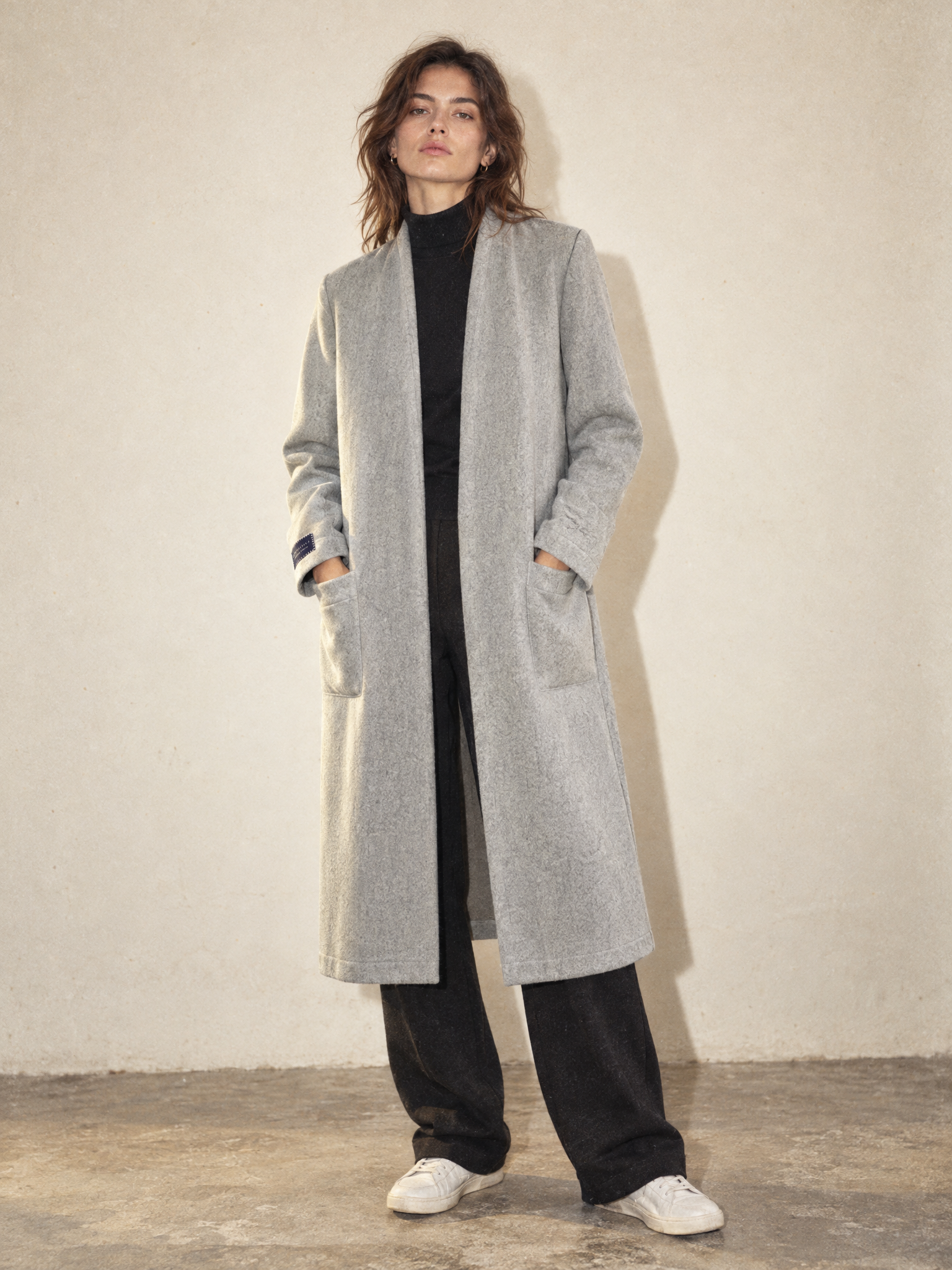 Female model wearing the Granite Island Sparkling Ash long grey kimono coat over a black outfit, showing its relaxed silhouette and minimalist design.