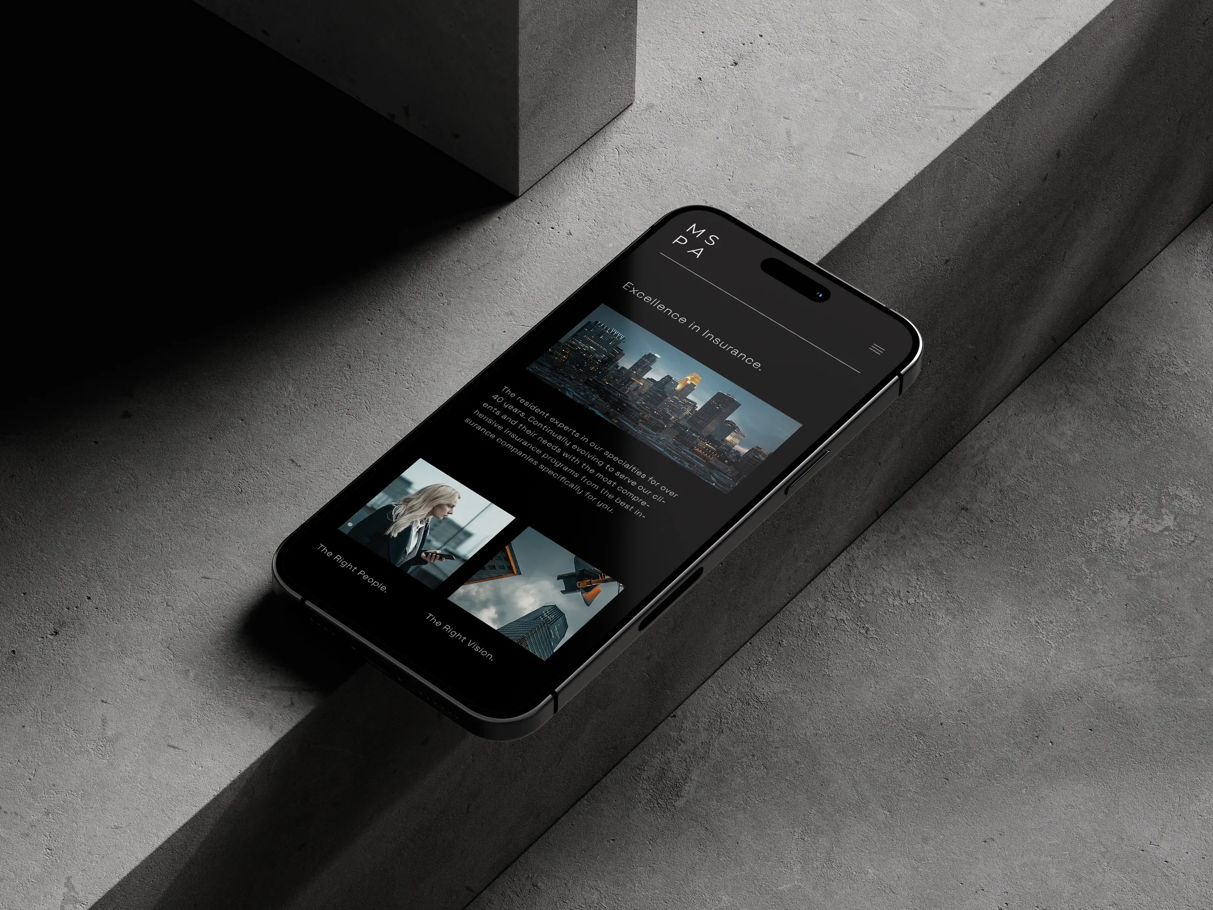 A smartphone displaying an insurance company's website with a cityscape photo, a woman using a tablet, and a city skyline, placed on a concrete surface with shadows.