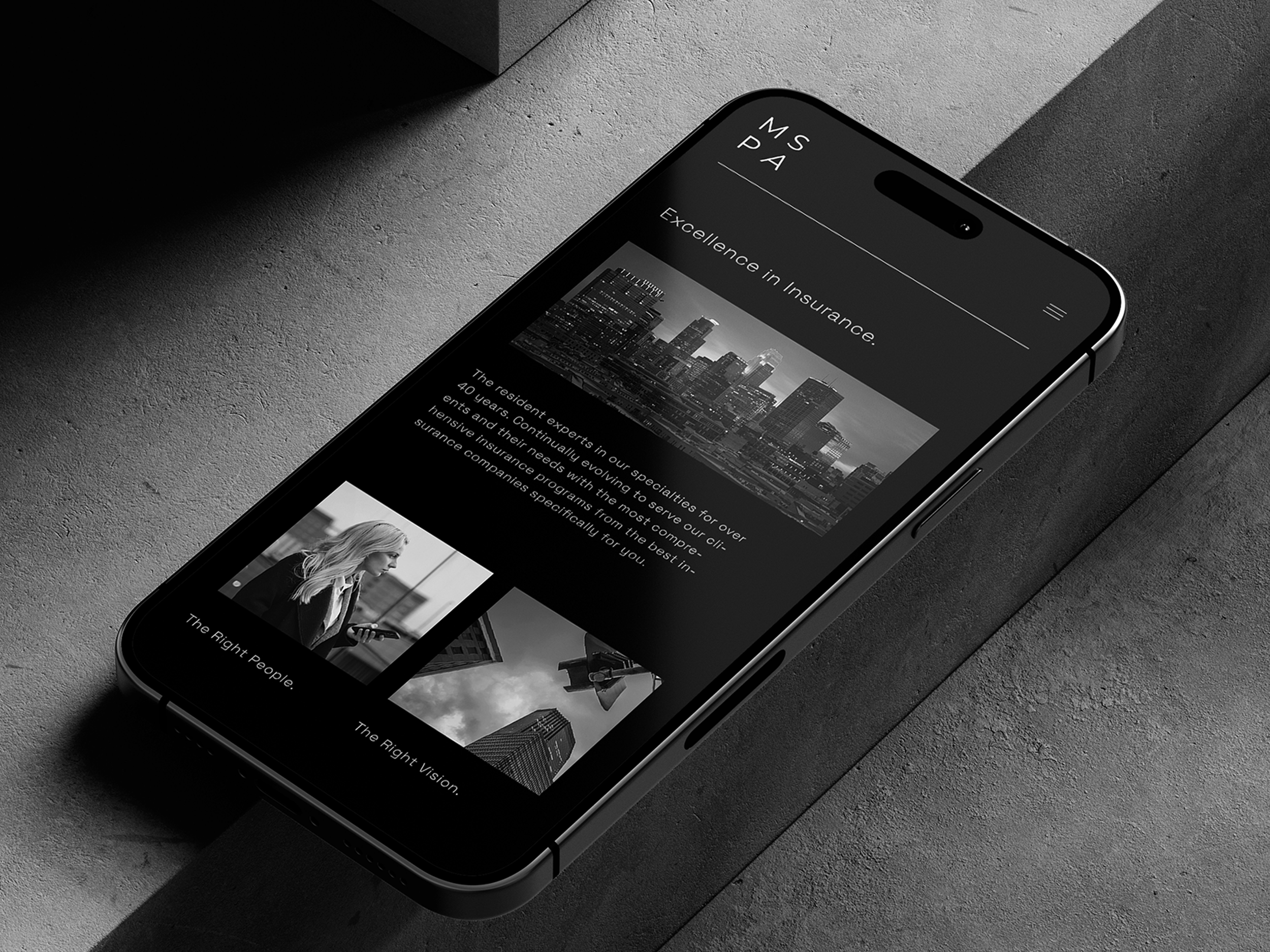 A smartphone on a gray surface displaying a website for an insurance company with a city skyline at the top, a black and white photo of a woman with a phone, and images of skyscrapers.