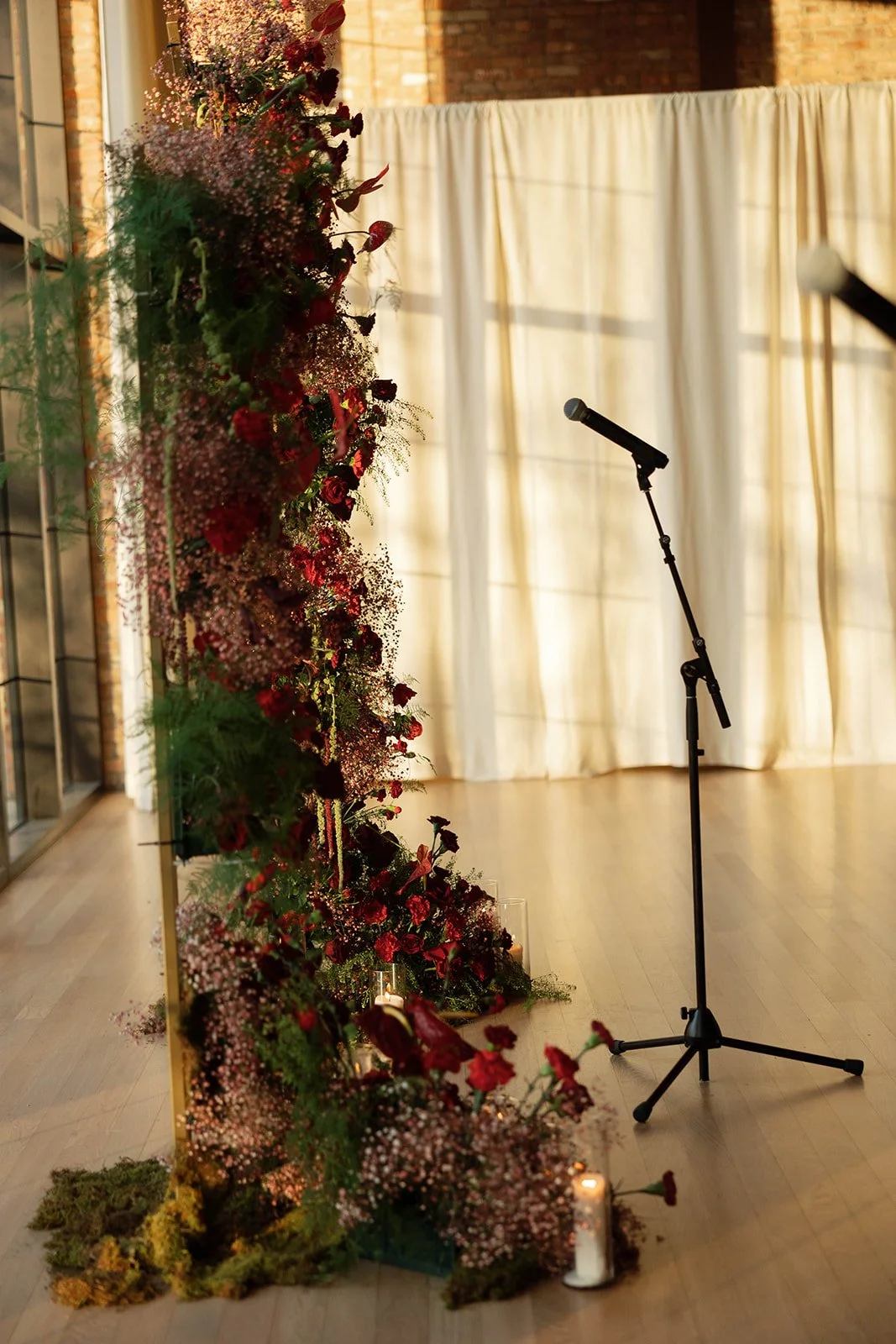red floral ceremony arch in sunlight