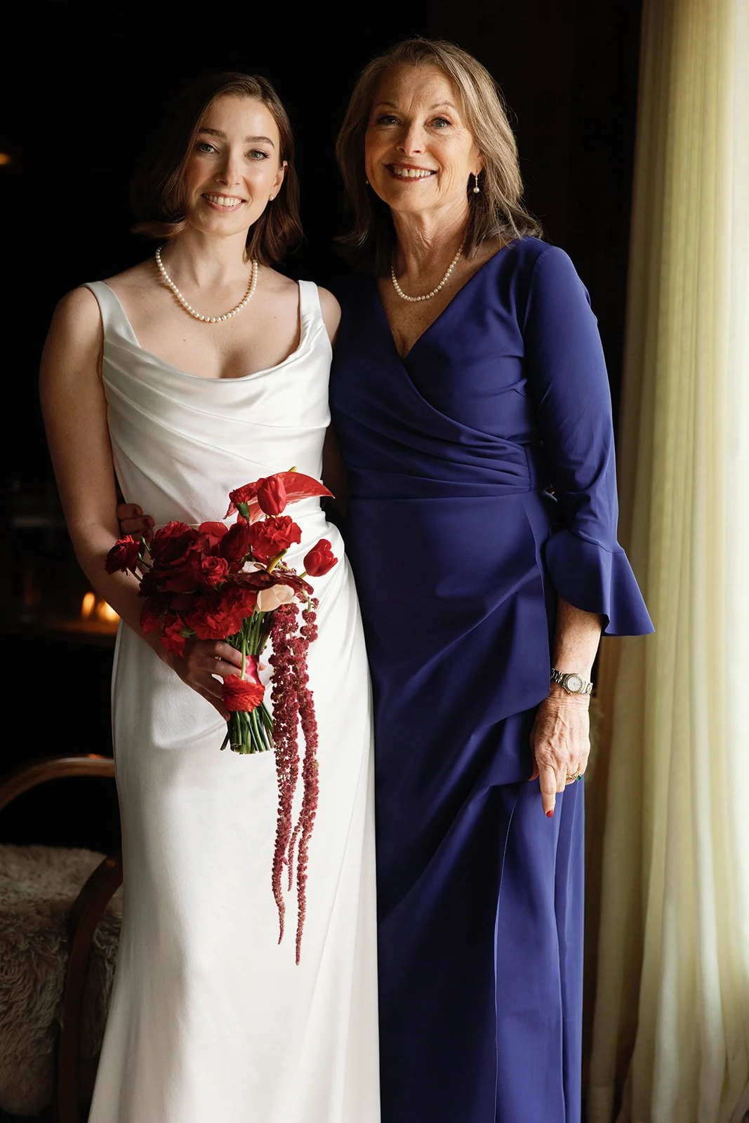 bride and mother with red flowers
