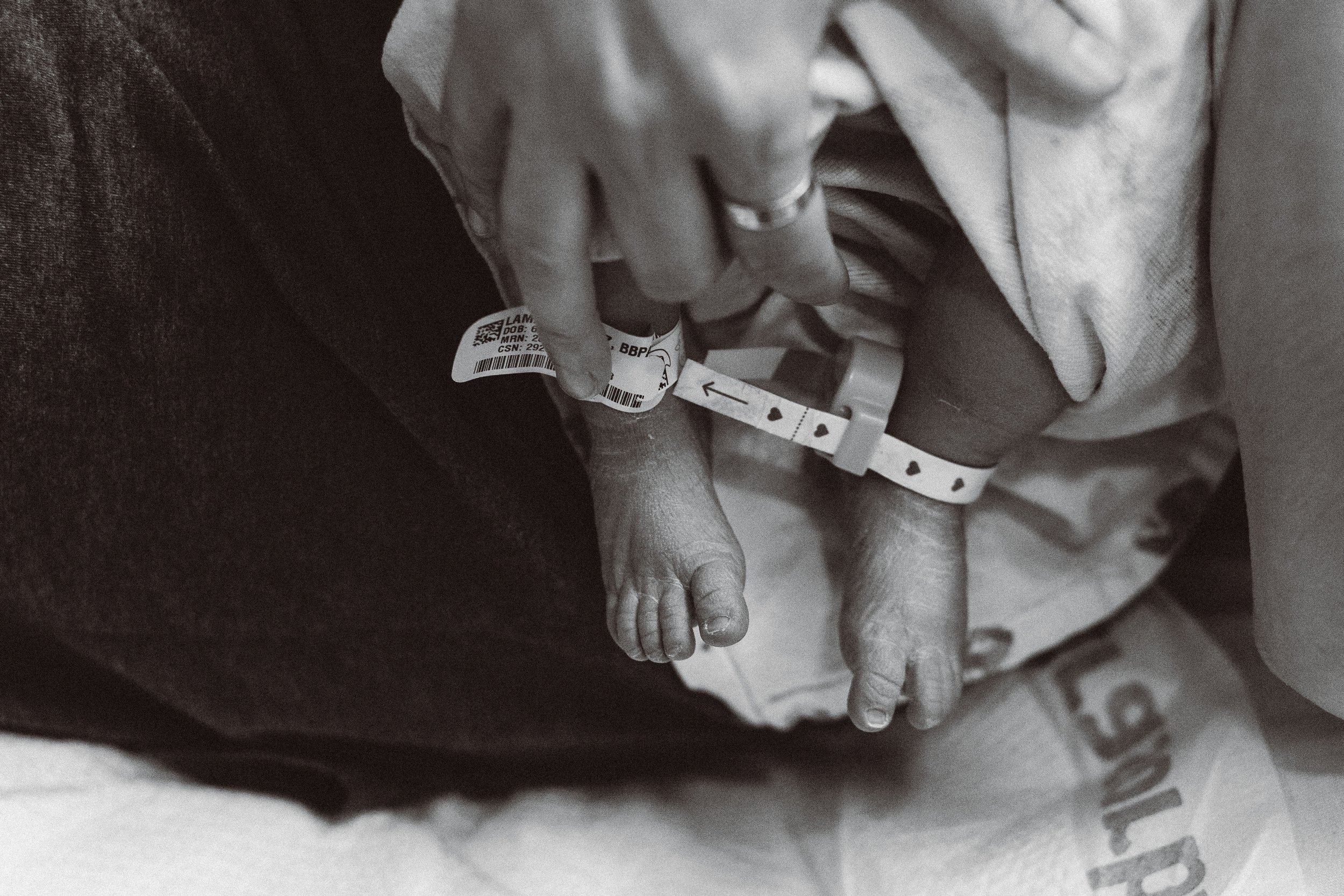 Close-up of a mom's hands with a new born and his feet, showing a birthing moment.