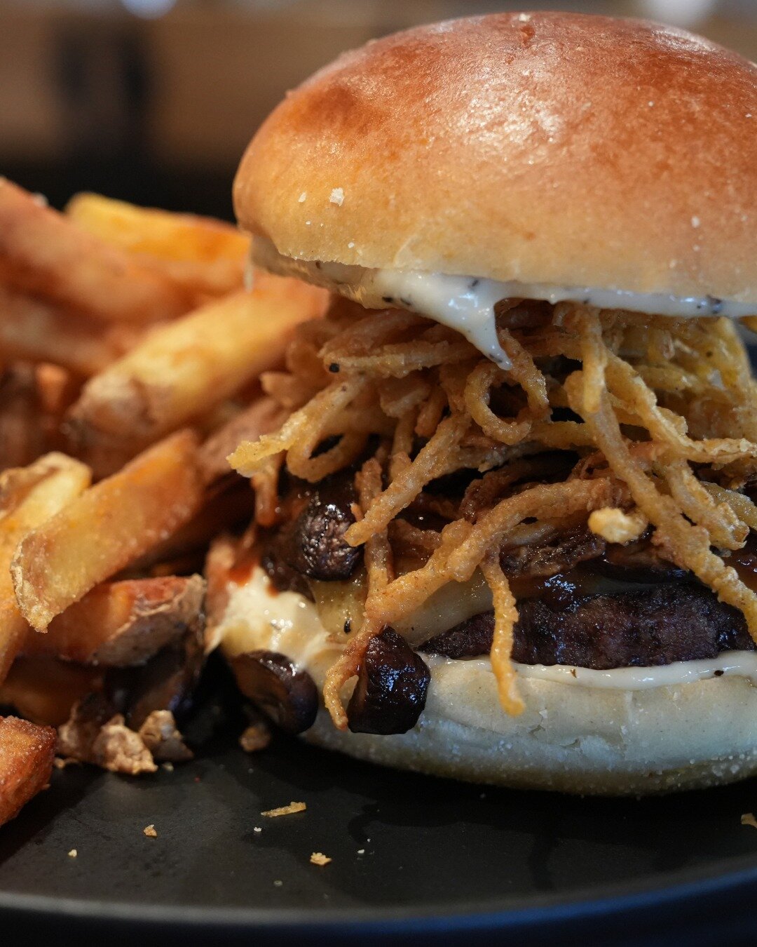 Our Steakhouse Burger features American Kobe beef from @rrqualitymeatsandseafood, crispy fried onion straws, saut&eacute;ed mushrooms, melty pepper jack cheese, garlic aioli, and house-made steak sauce. Start the week off right and come get you some!