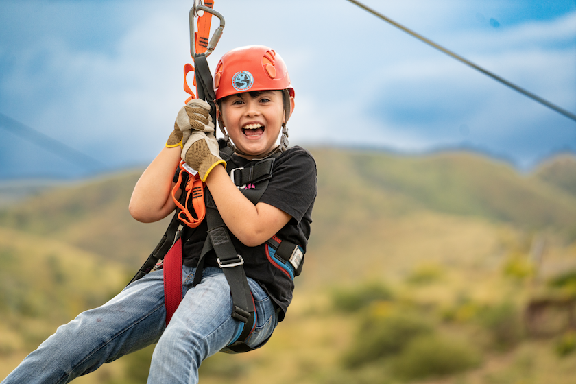 Child ziplining on an outdoor adventure course near Tucson