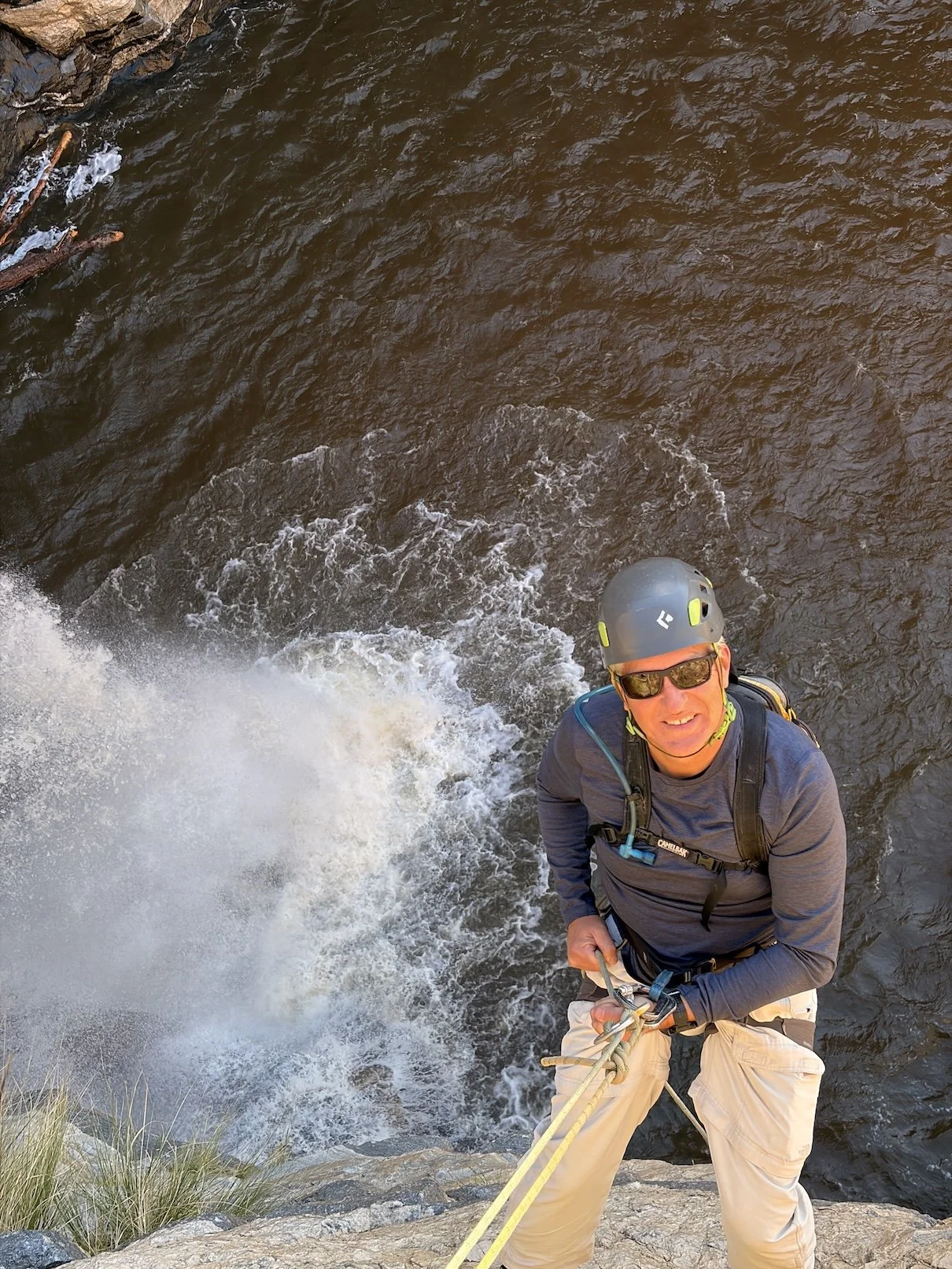 Guest beside a waterfall and rappel ropes during a guided Tucson canyoneering trip