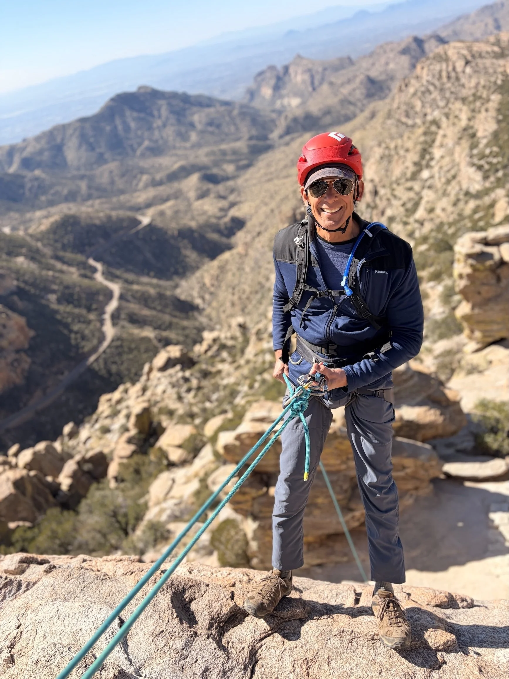 Guest rappelling on Mount Lemmon with mountain views above Tucson.