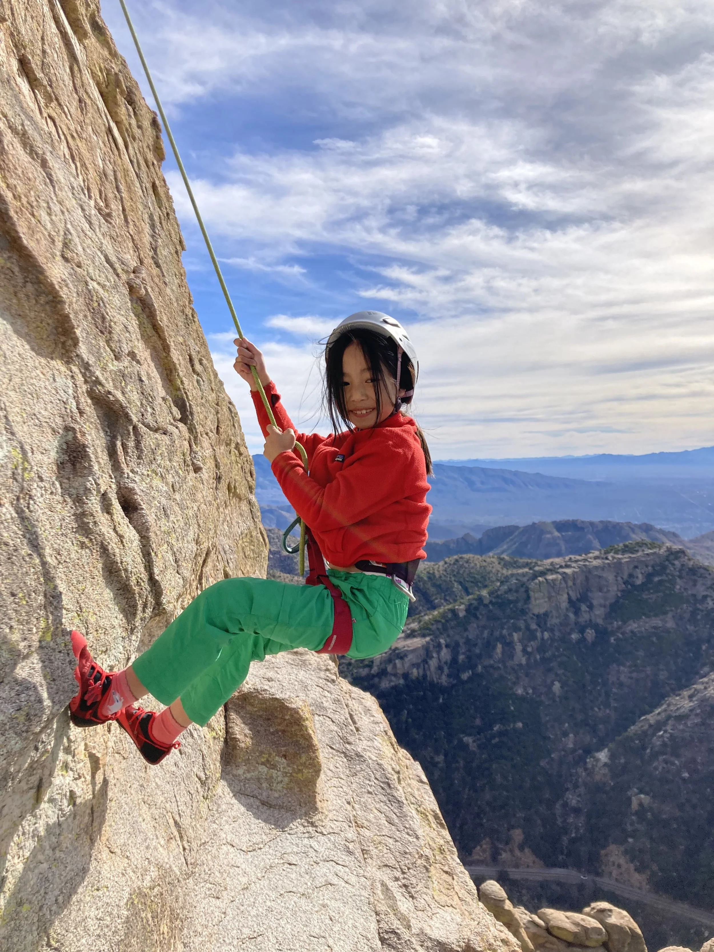Child rappelling on a granite cliff during a guided Mount Lemmon adventure